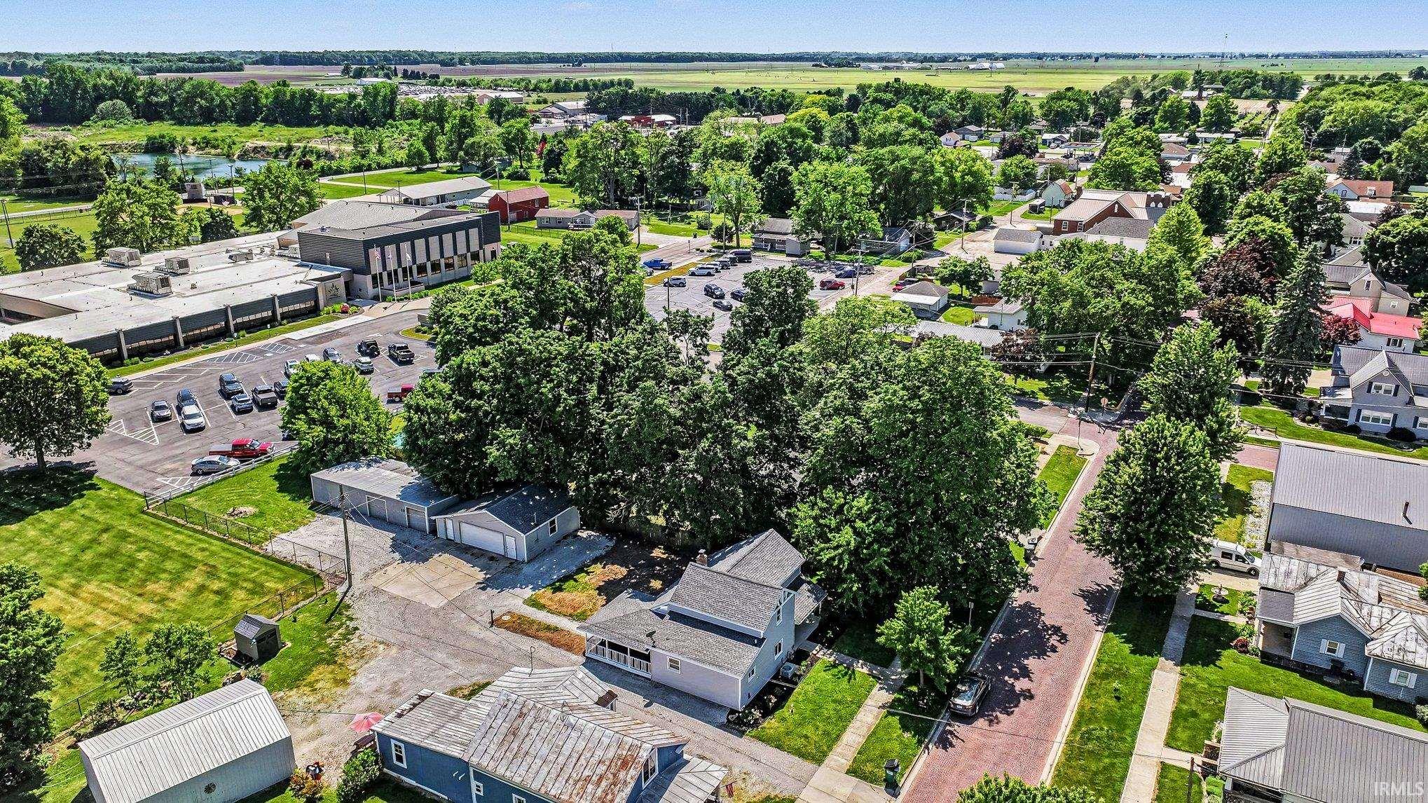 Aerial perspective showcasing a residential street with mature trees and a brick paver road