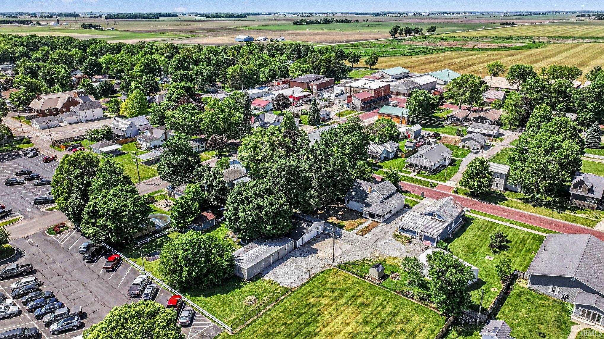 Aerial perspective showcasing a residential area with varied home styles, mature trees, and manicured lawns