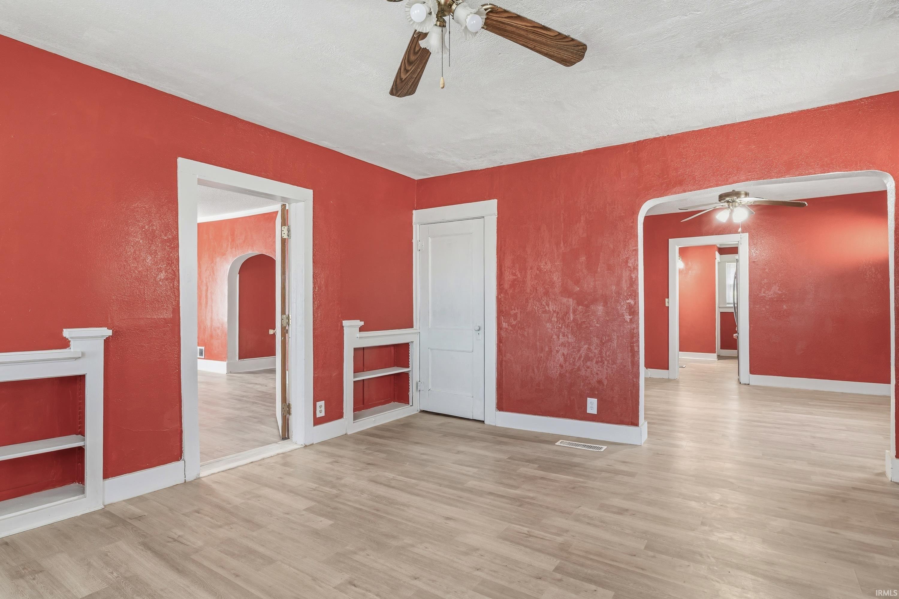 Spacious interior featuring wood-finish flooring, white trim, and multiple doorways