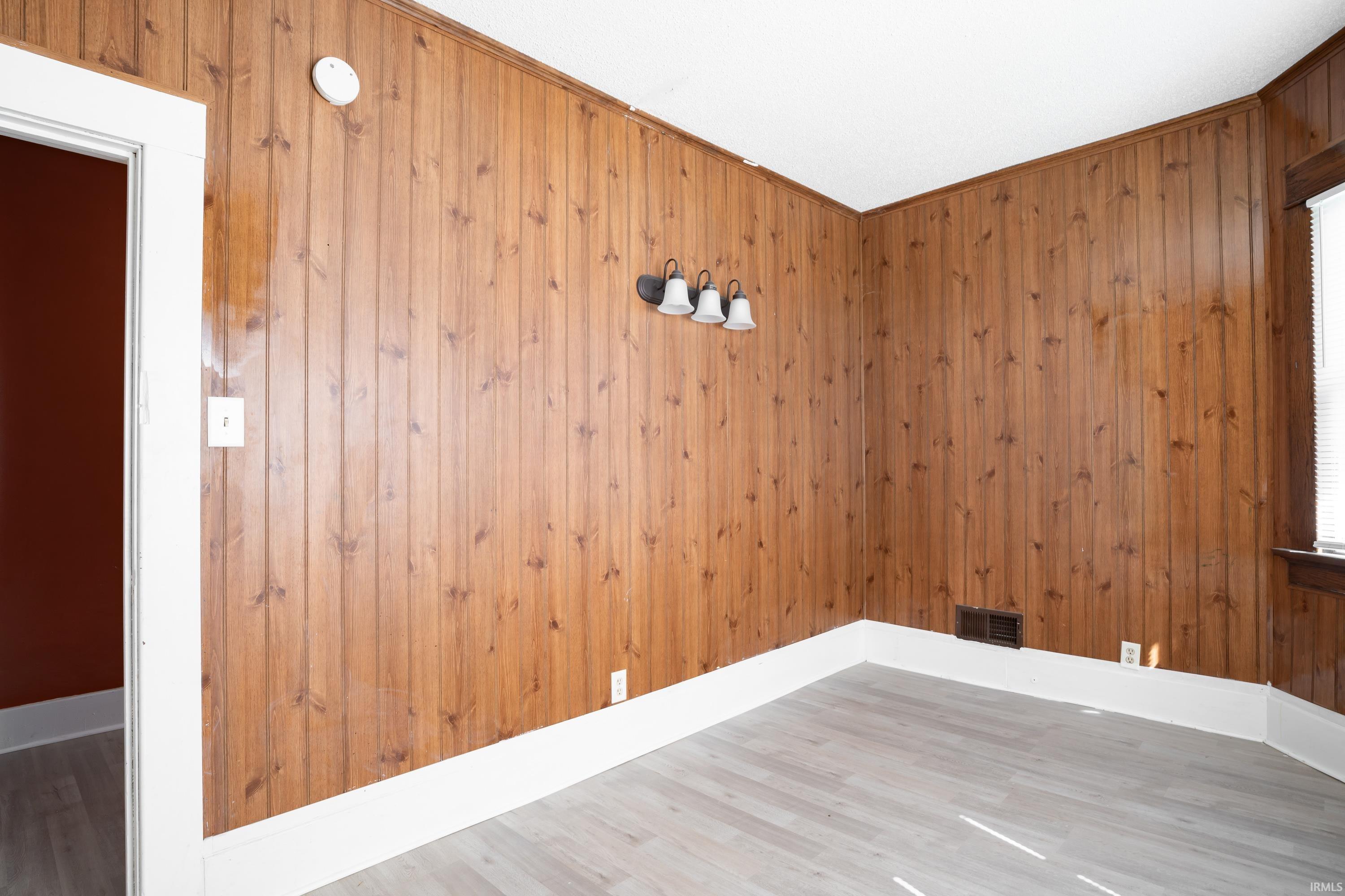 Wood paneling walls featuring white trim