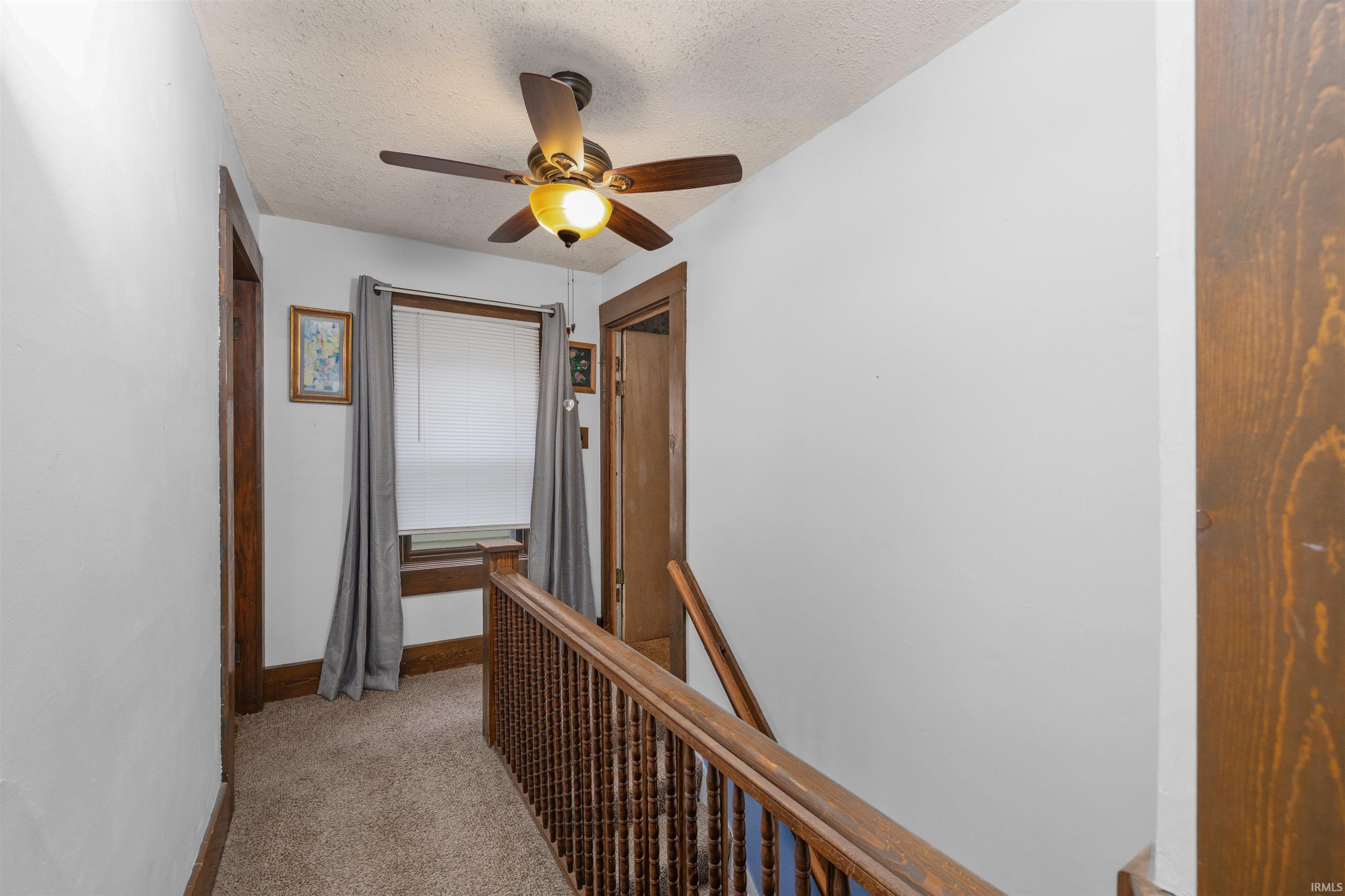 Upper landing featuring carpeted flooring and white walls