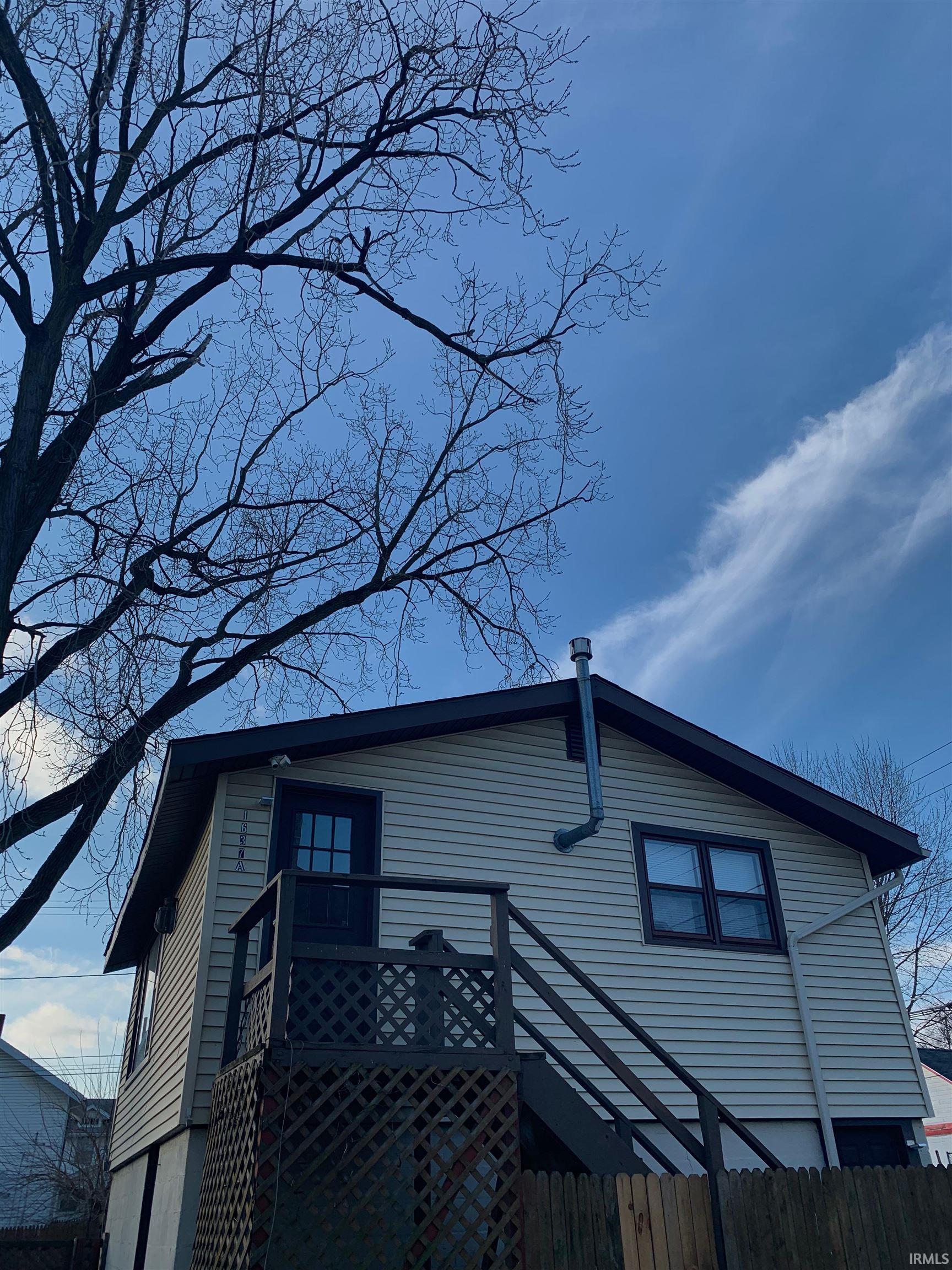 Two-story siding exterior featuring a dark trim and a gabled roofline