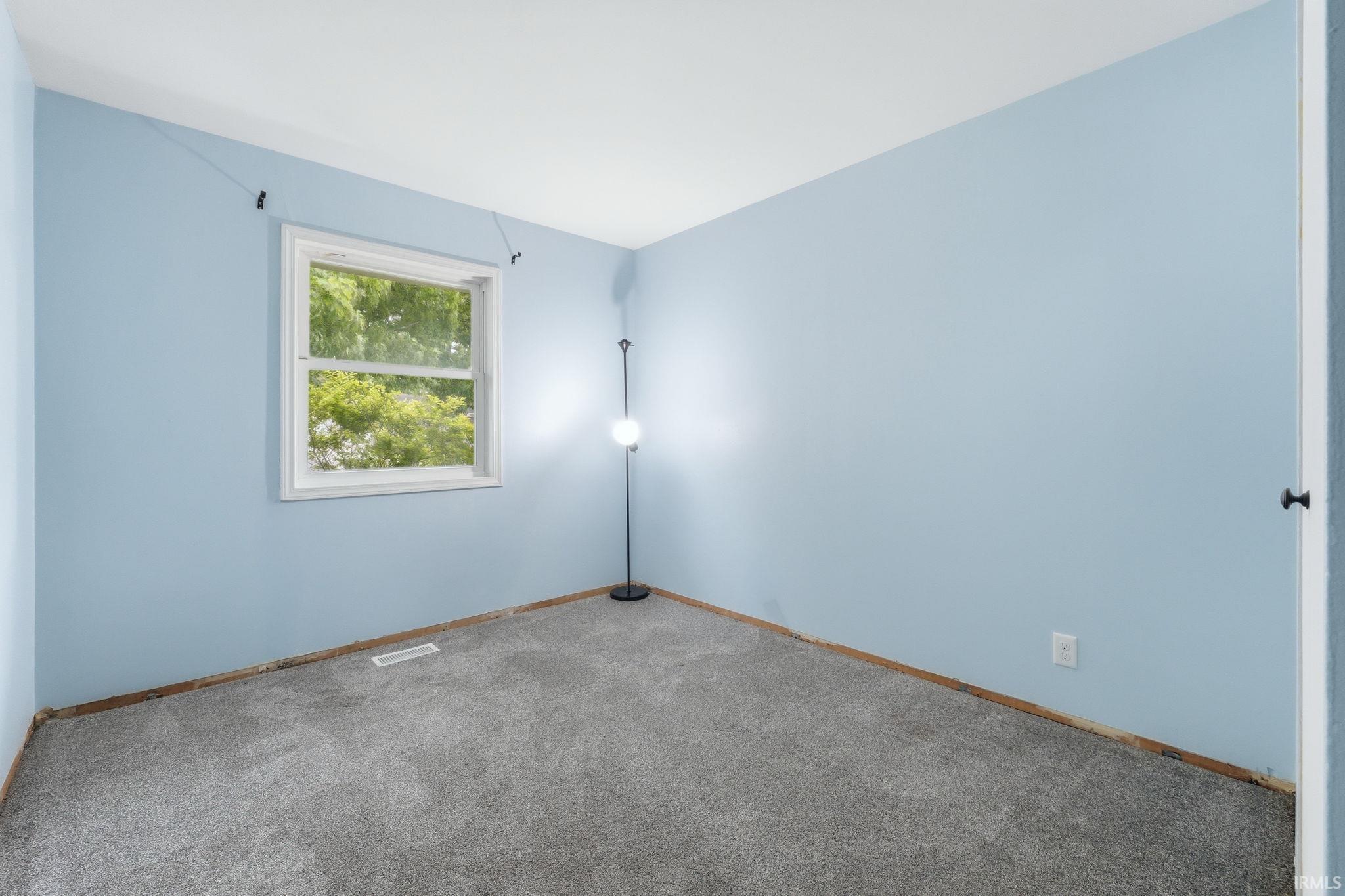 Interior room featuring light blue walls and neutral gray carpeting
