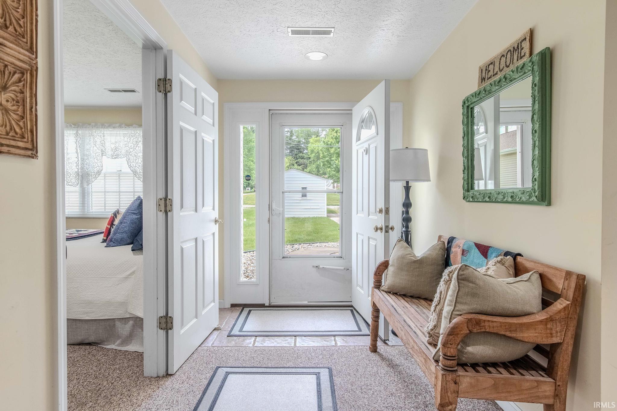 Foyer entryway featuring a half-lite front door with sidelite, tile flooring, recessed lighting, and a white six-panel interior door