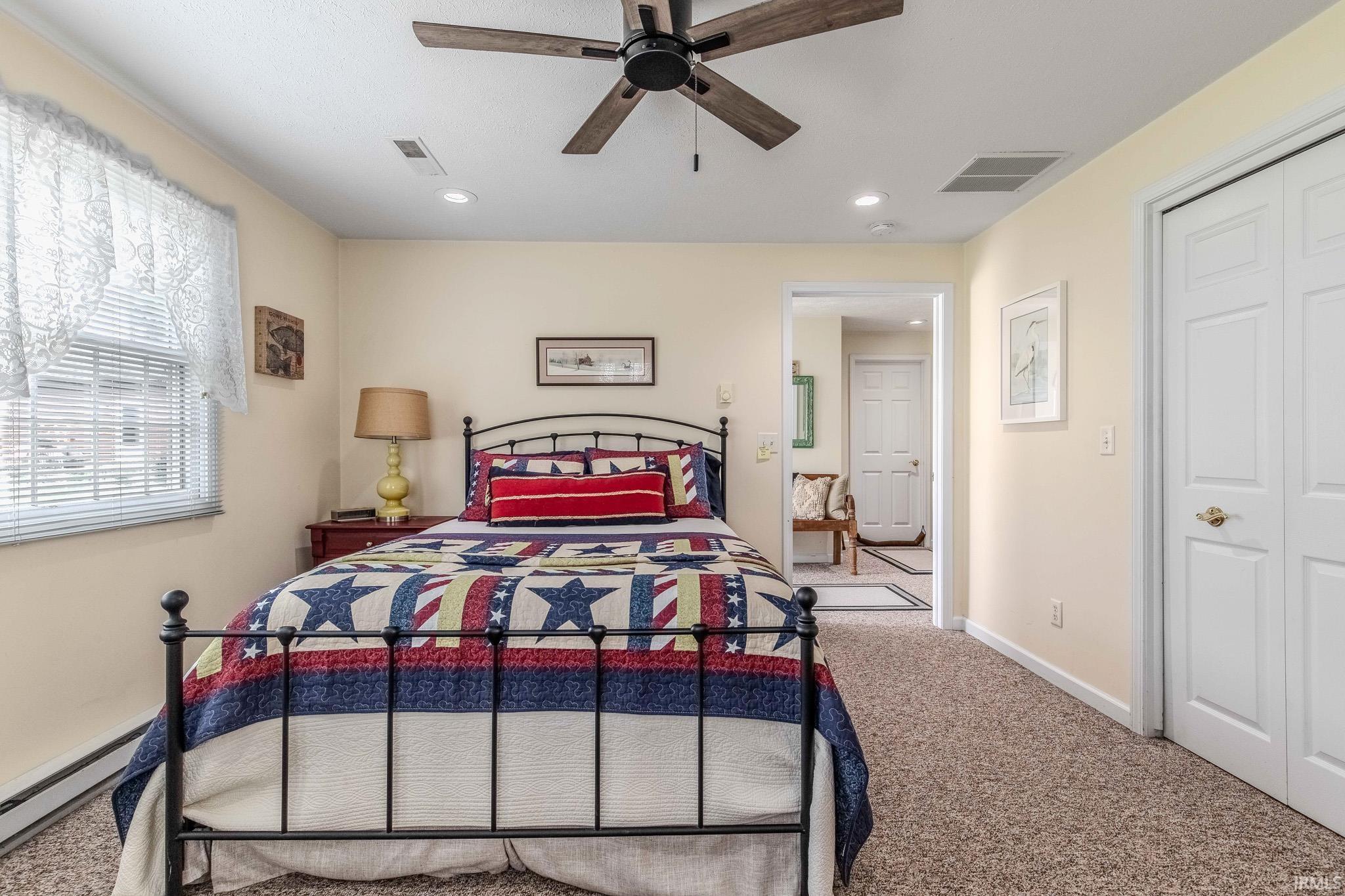 Carpeted room featuring a ceiling fan, recessed lighting, and a double-door closet