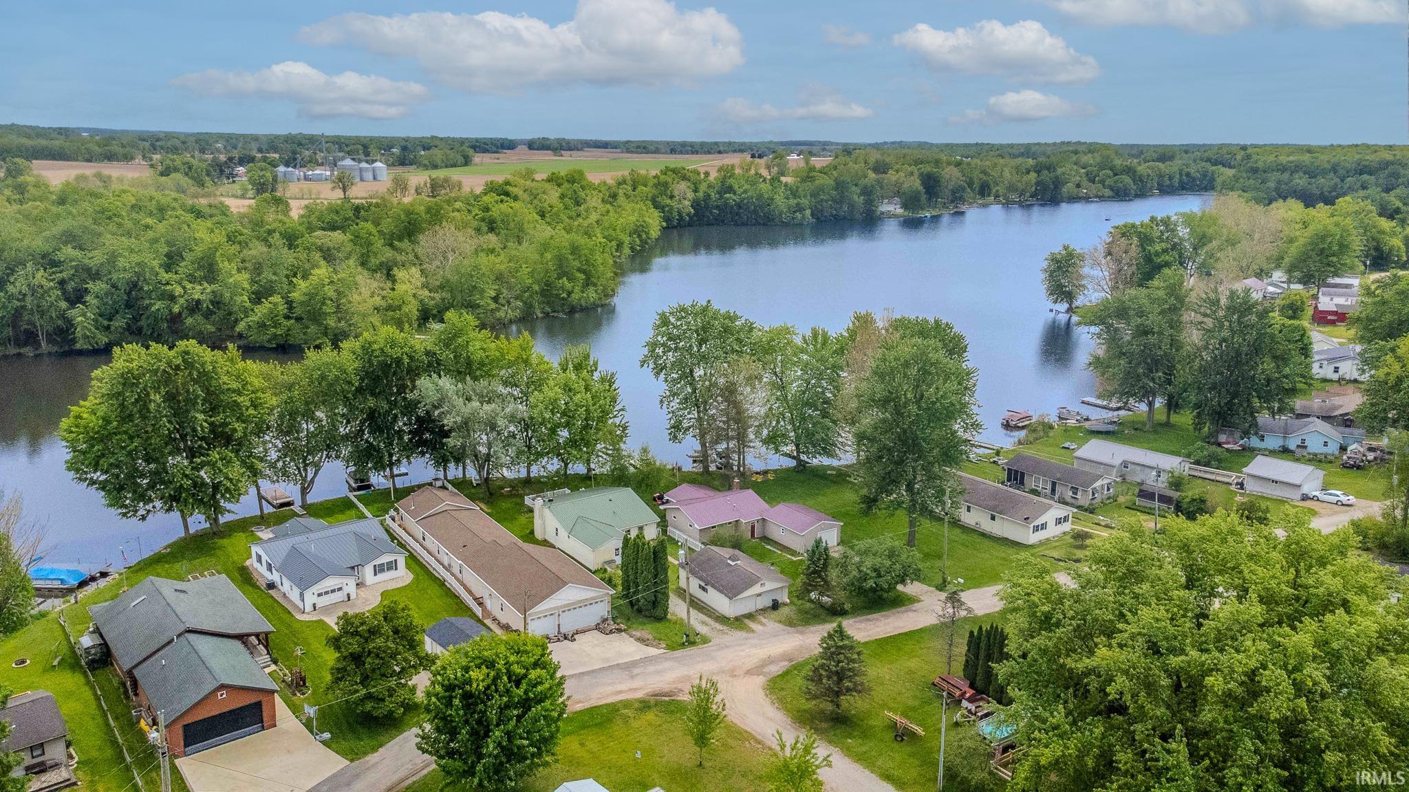 Waterfront property featuring a serene river, surrounding woodlands, and residential homes