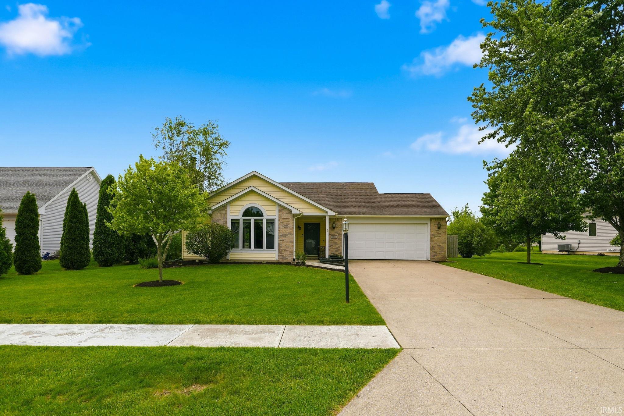 Ranch-style residence featuring a prominent bay window and an attached two-car garage