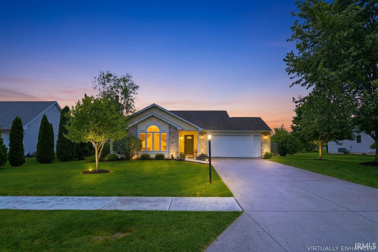 Ranch-style residence featuring a prominent arched window, stone facade accents, and a two-car garage