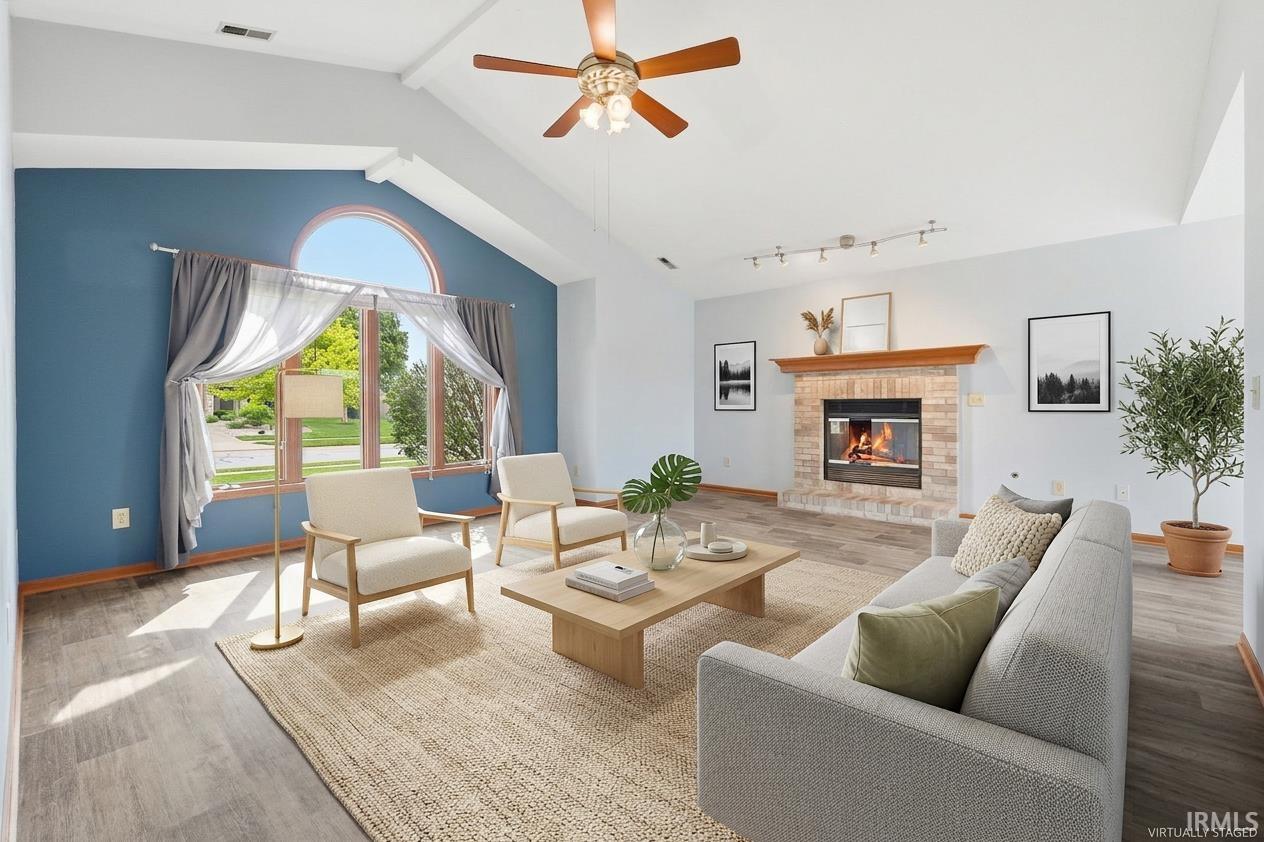 Vaulted ceilings complement the prominent arched window feature in this living area