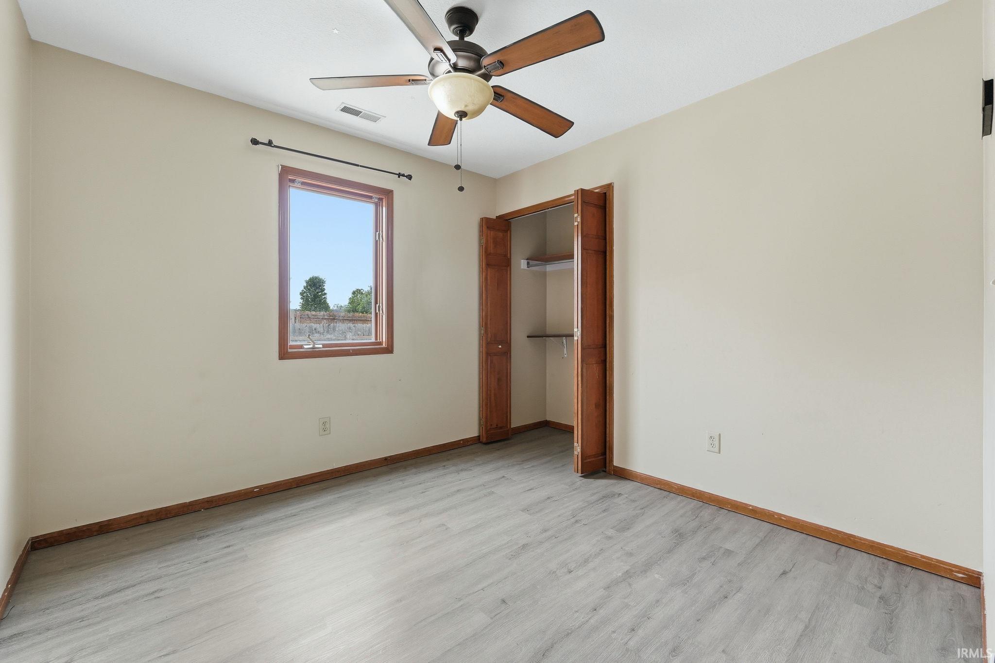Room featuring light-colored walls and wood-finish flooring