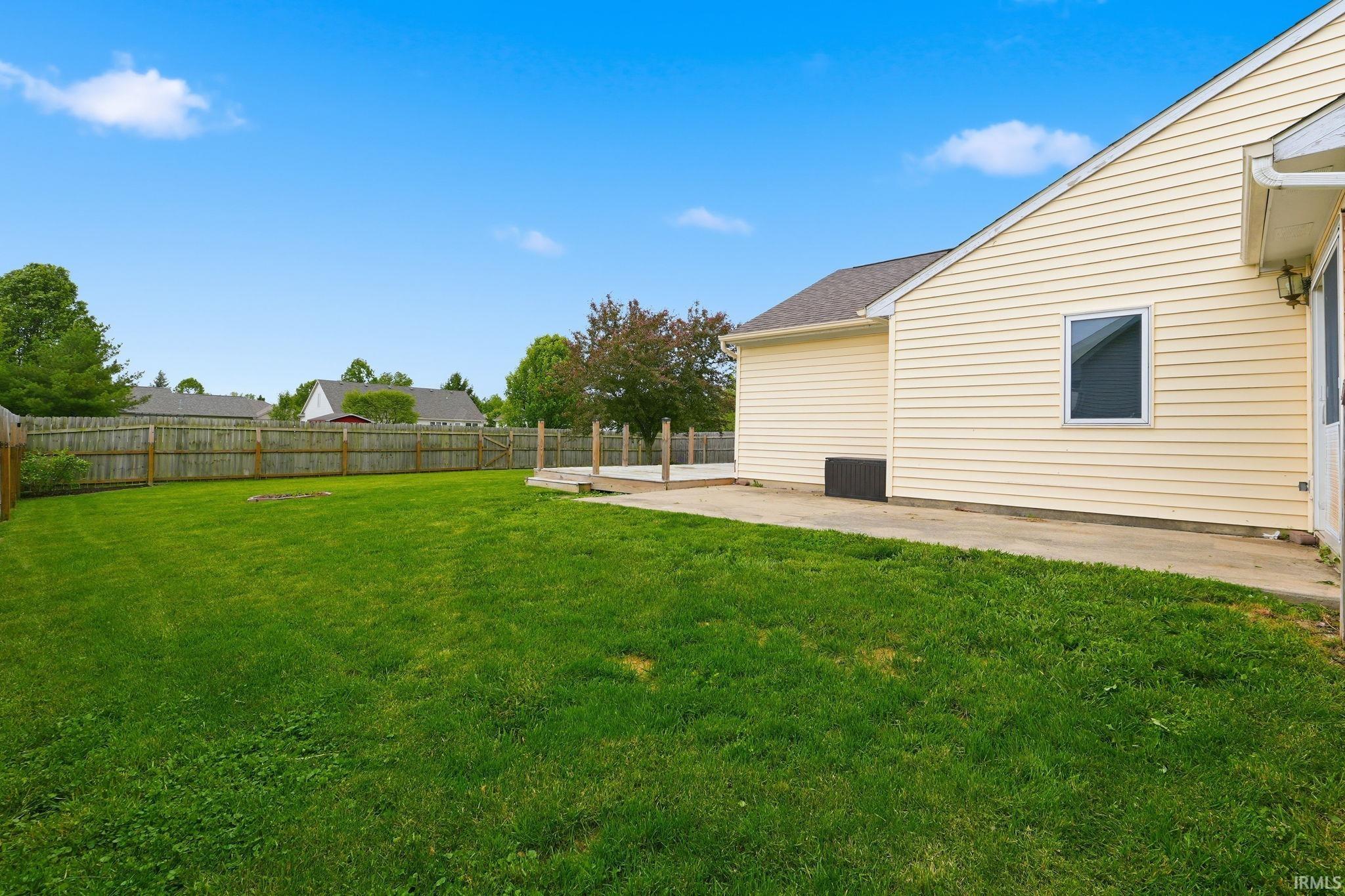 Expansive green lawn with a wood privacy fence