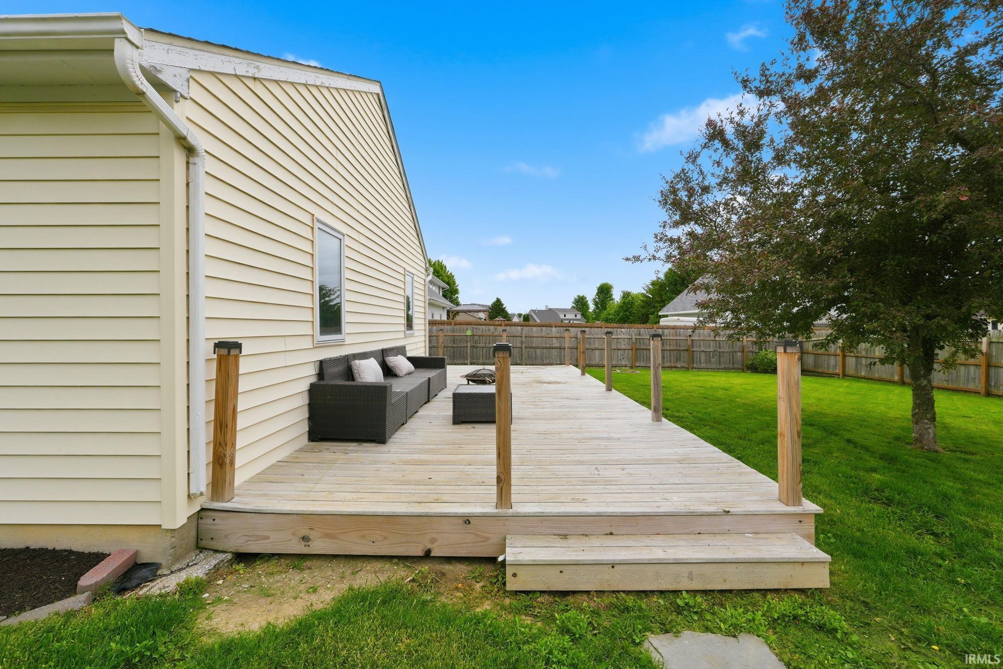 Spacious wood deck with integrated steps, featuring solar-capped posts and a wide open-air design