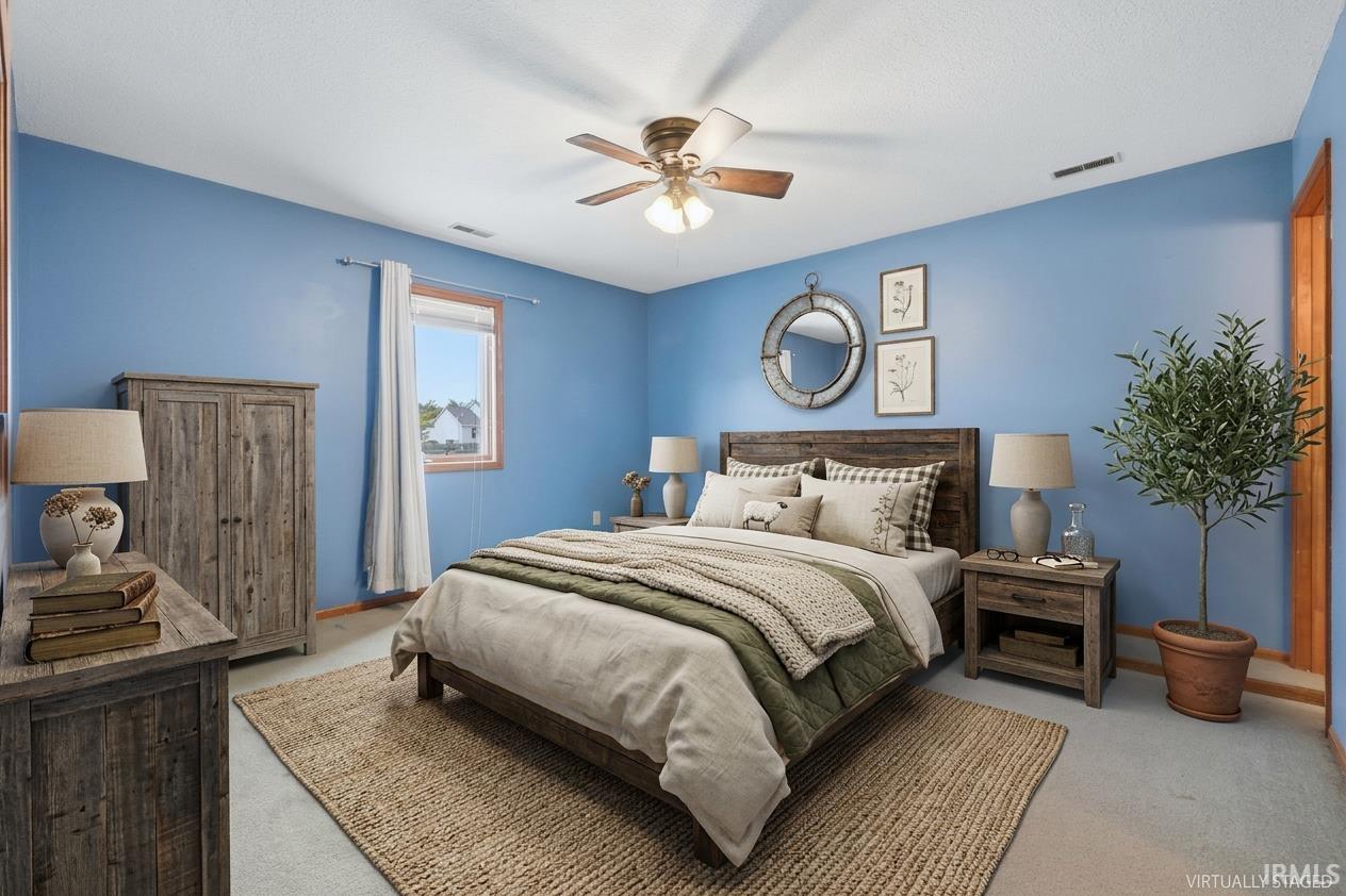 Bedroom featuring a window with natural wood trim, a ceiling fan, and light blue walls