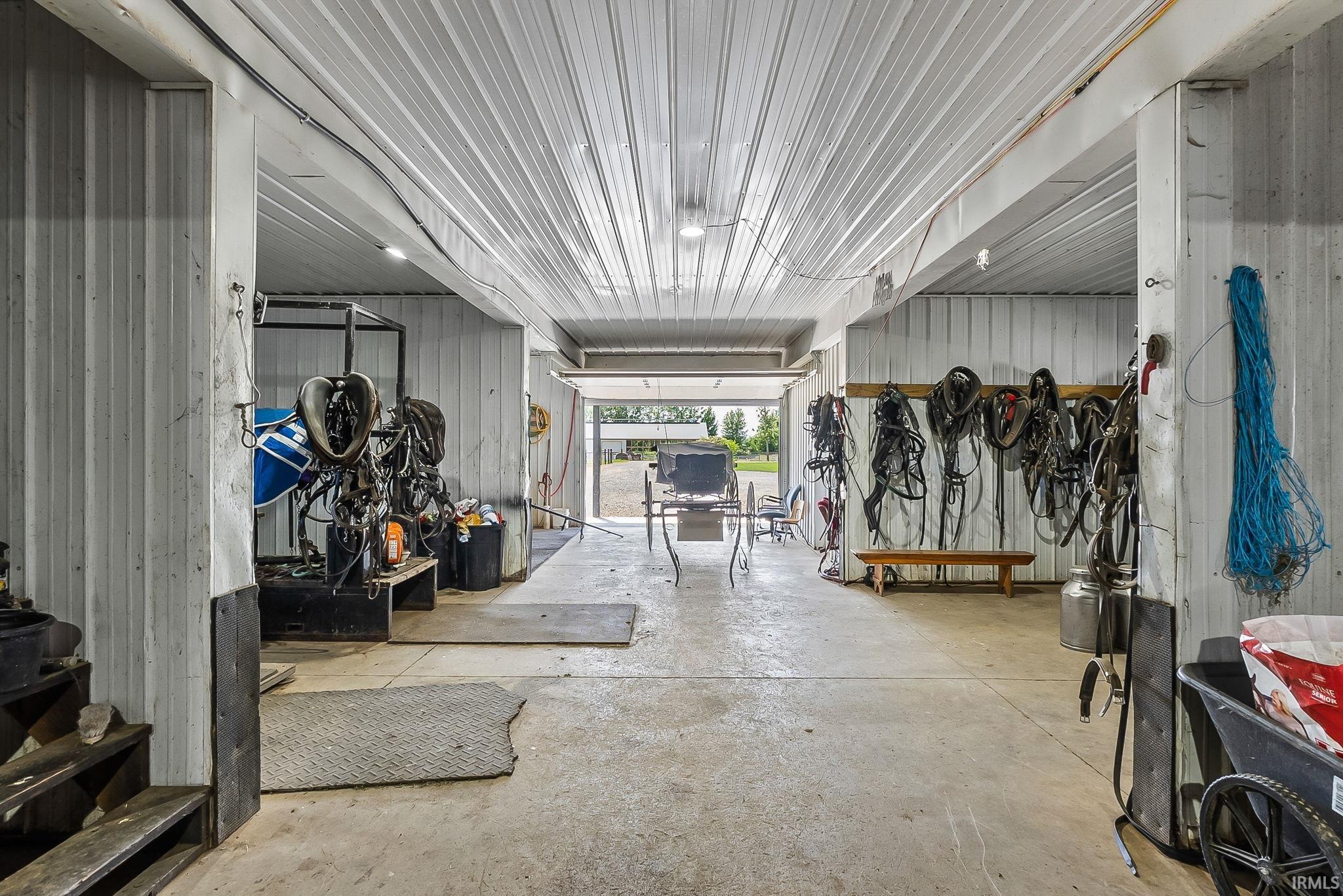 Spacious barn interior featuring a concrete floor, corrugated metal walls, and a matching metal ceiling