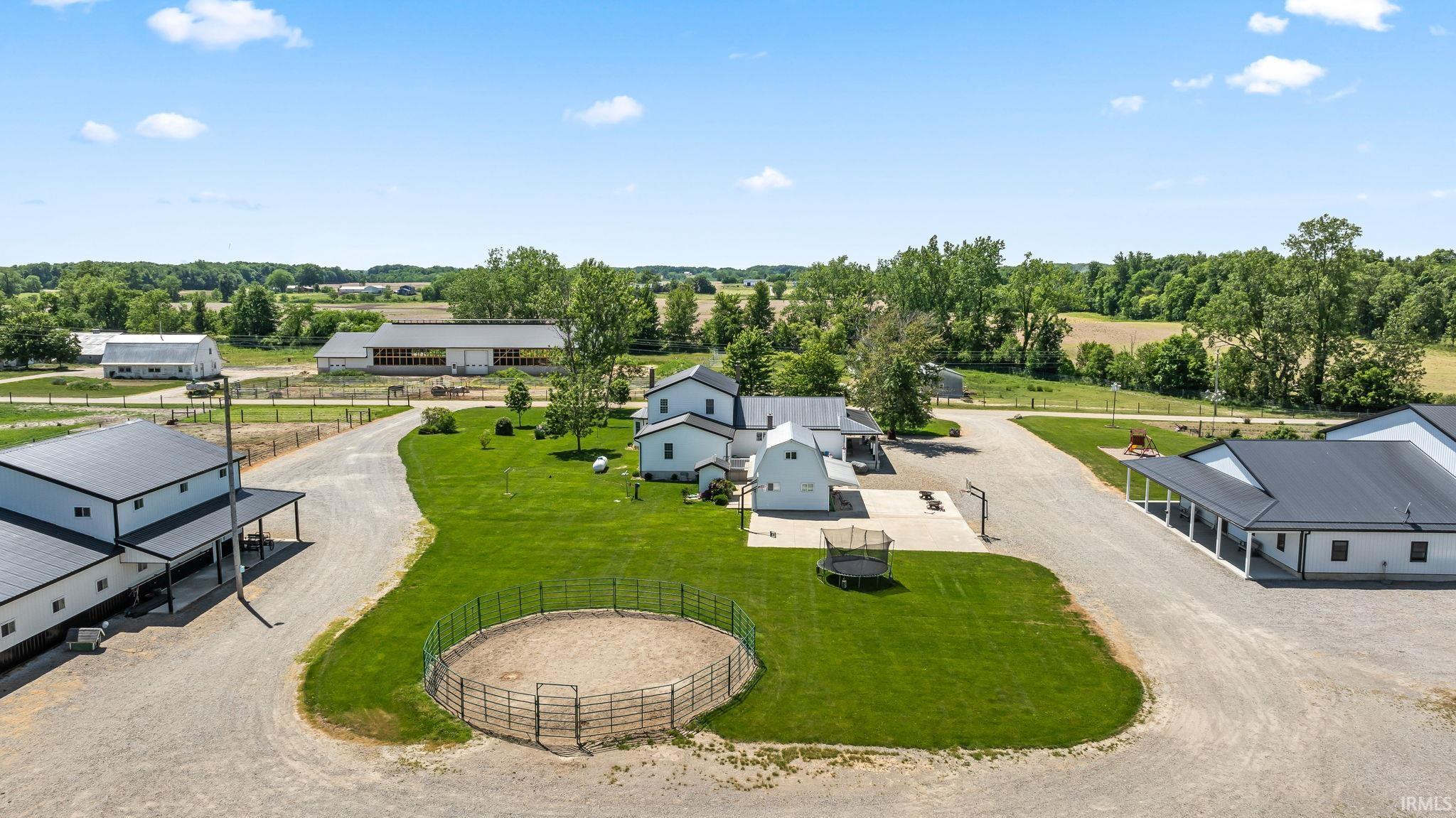 Expansive property featuring multiple outbuildings, gravel driveways, and manicured green spaces