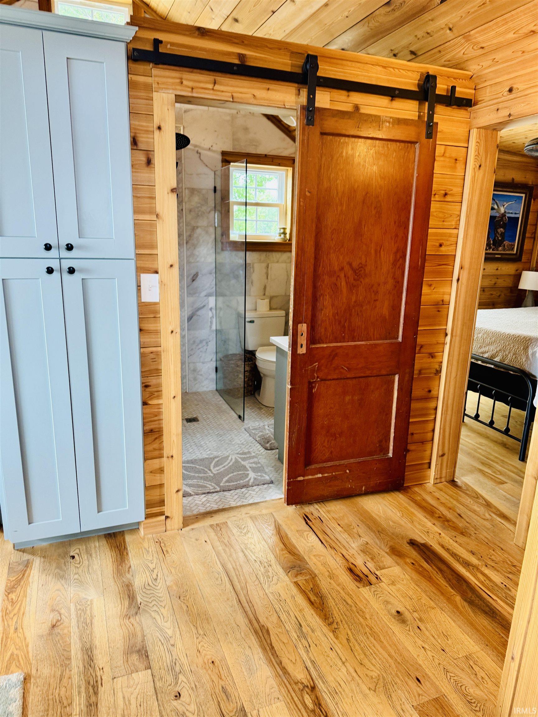 Warm wood-finish flooring extending into the room