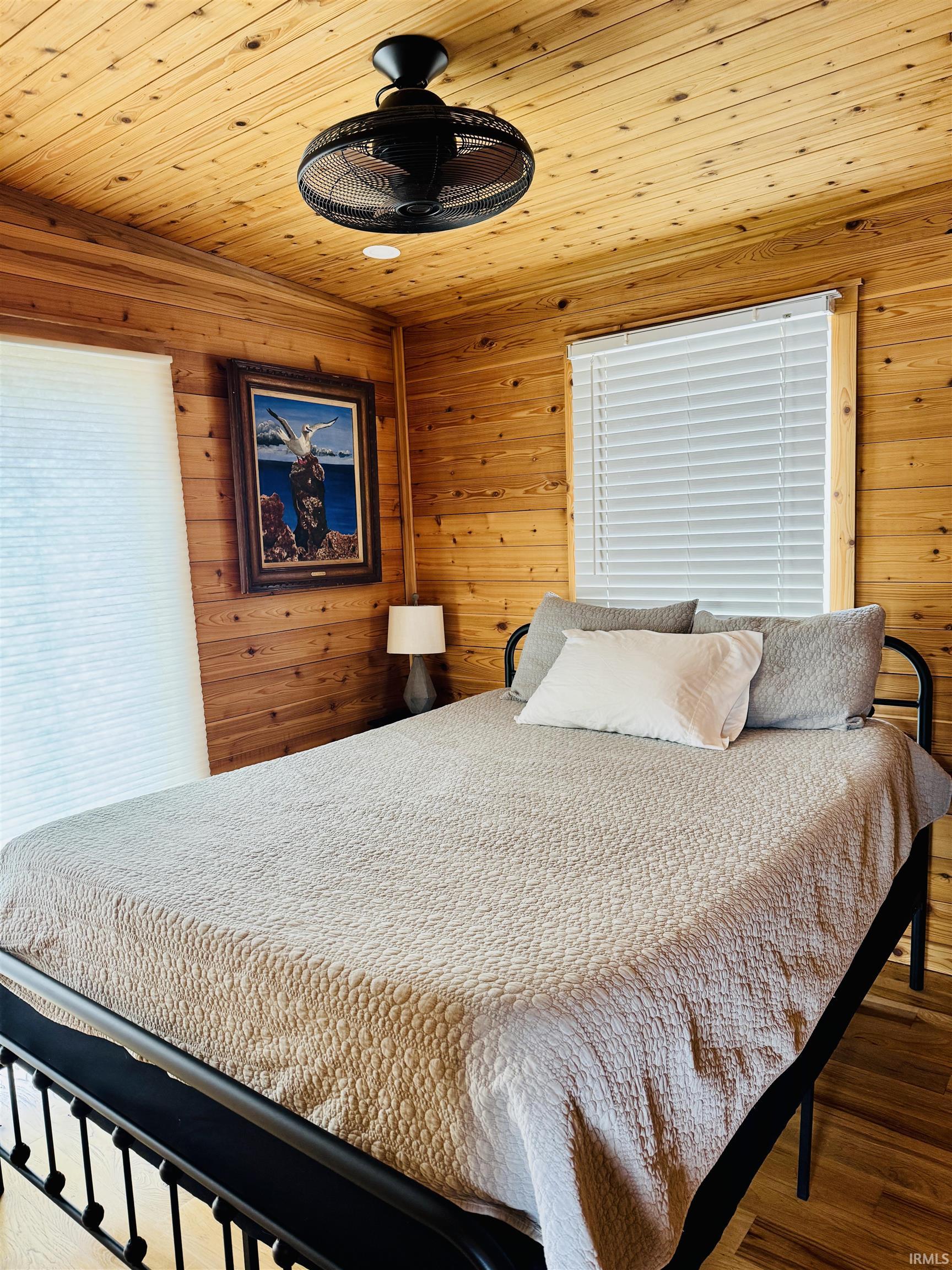 Wood-paneled room featuring a slatted wood ceiling, a black ceiling fan, and recessed lighting