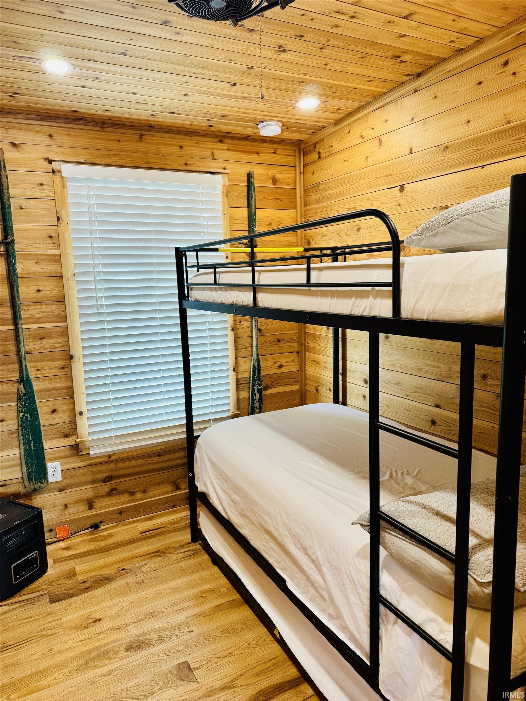 Room featuring wood-finish walls and ceiling, recessed lighting, and a window with blinds