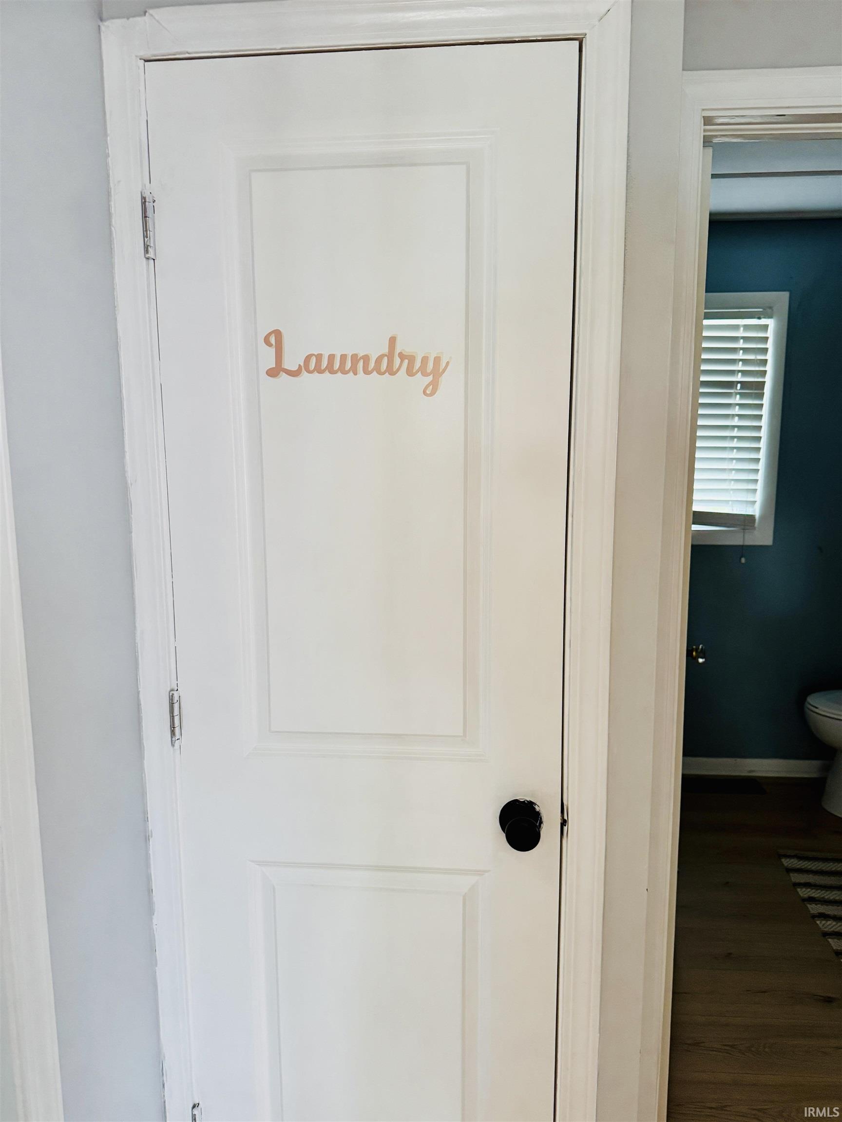 Dedicated laundry area featuring a white paneled door with a black knob