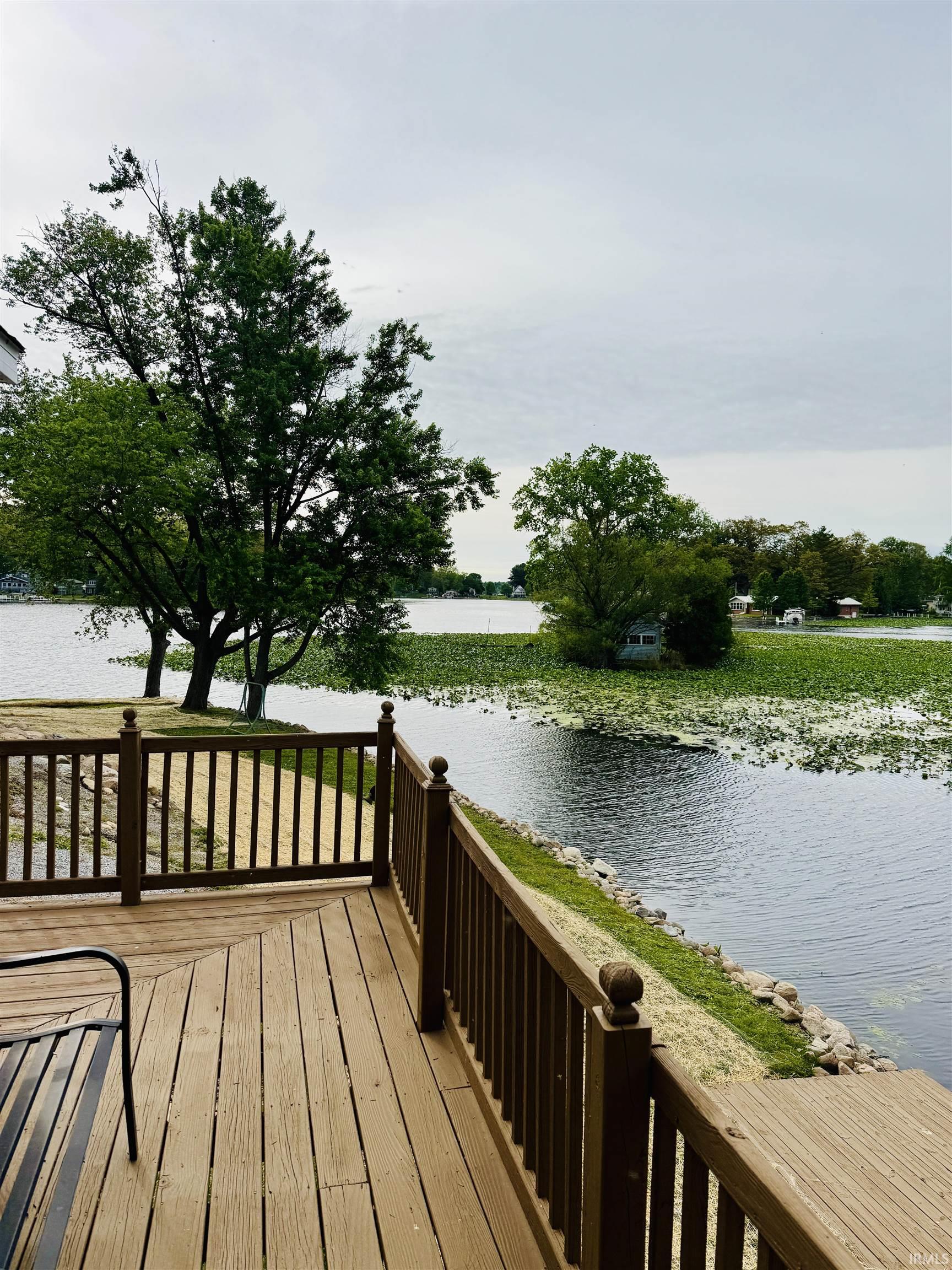 Wood-finish deck with a perimeter railing overlooking a body of water