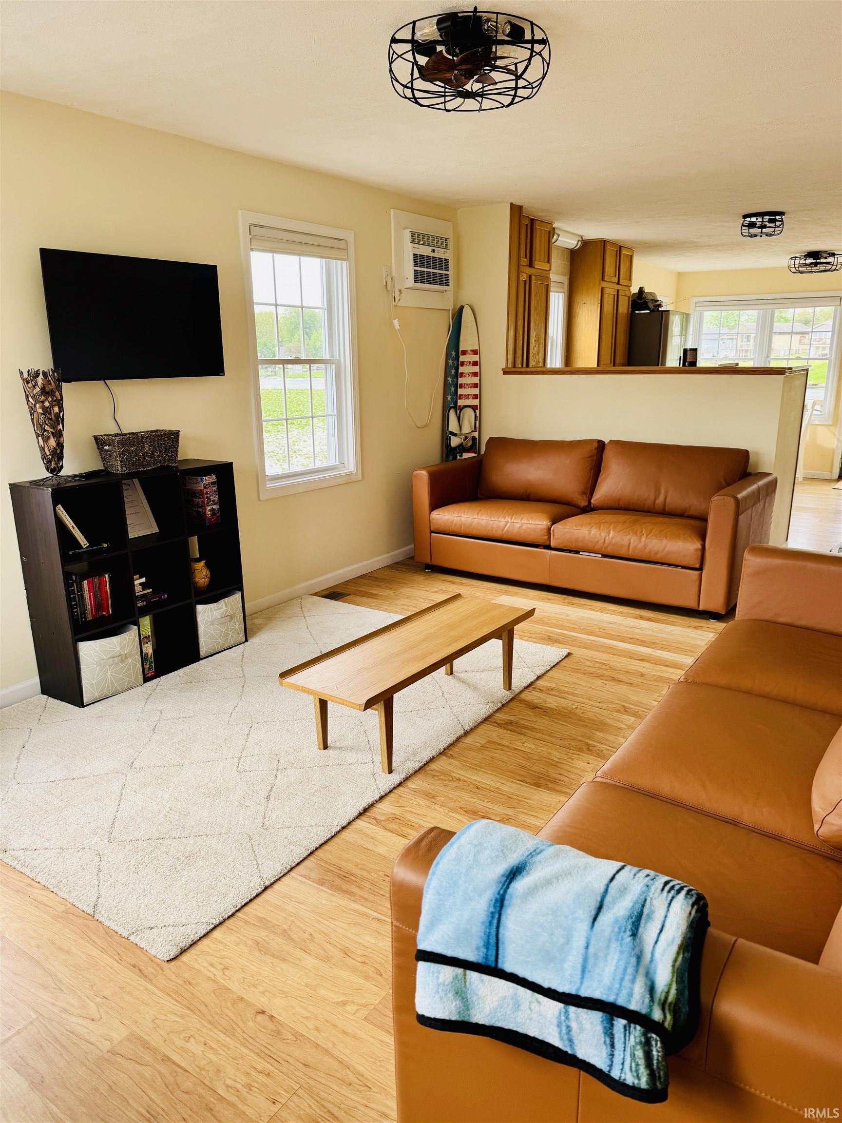 Bright living space featuring wood-finish flooring and a neutral color palette