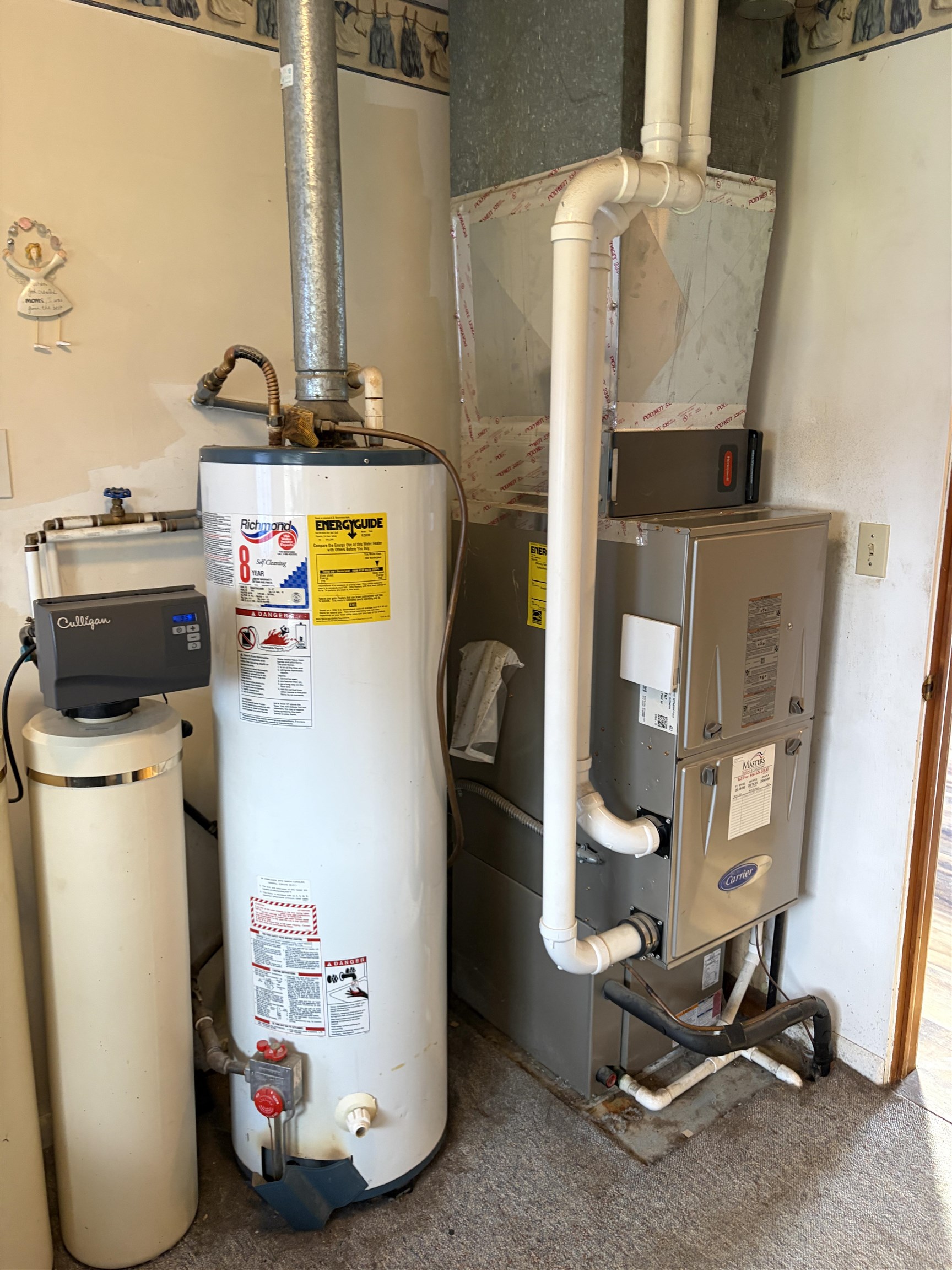 Utility area featuring a water heater, furnace, and water filtration system