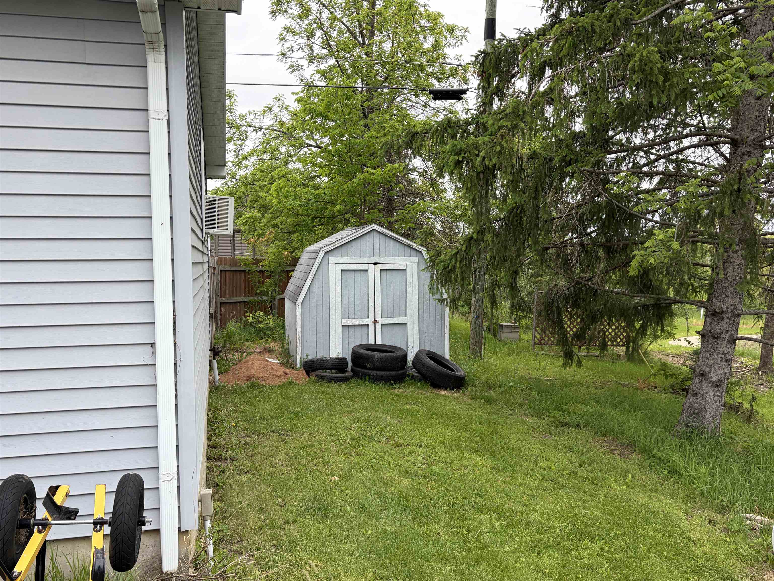 Gable-roofed shed with double doors and light blue siding
