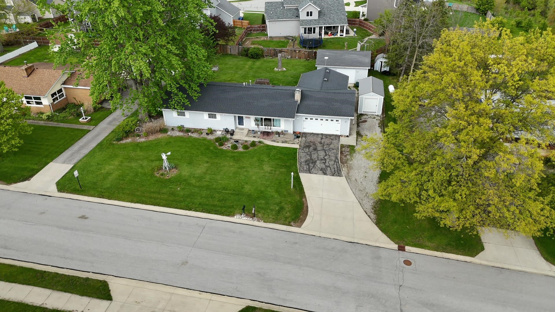 Ranch-style residence featuring a prominent front lawn with established landscaping