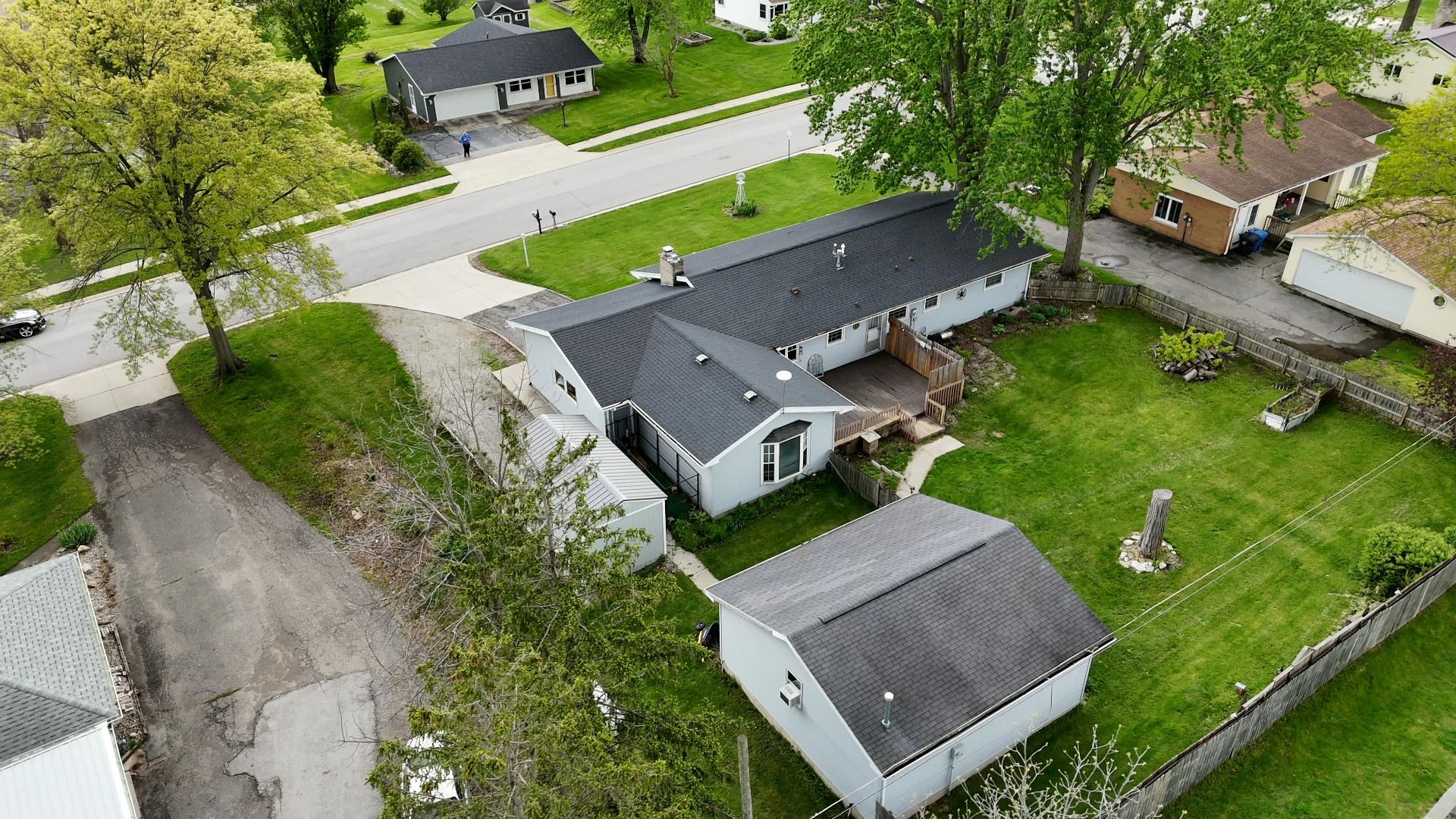 Ranch-style residence featuring a dark shingle roof and light-colored siding
