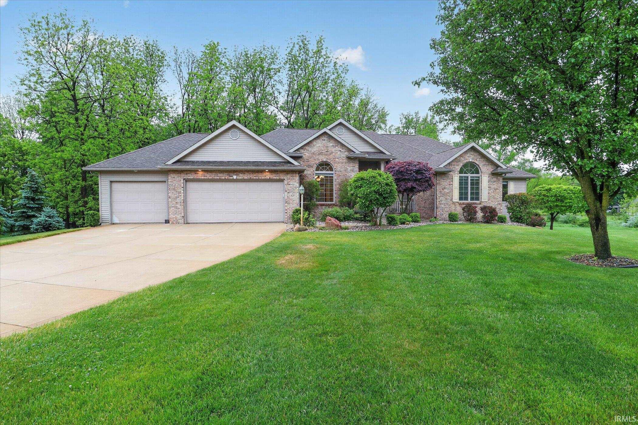 Brick and siding exterior featuring a three-car garage