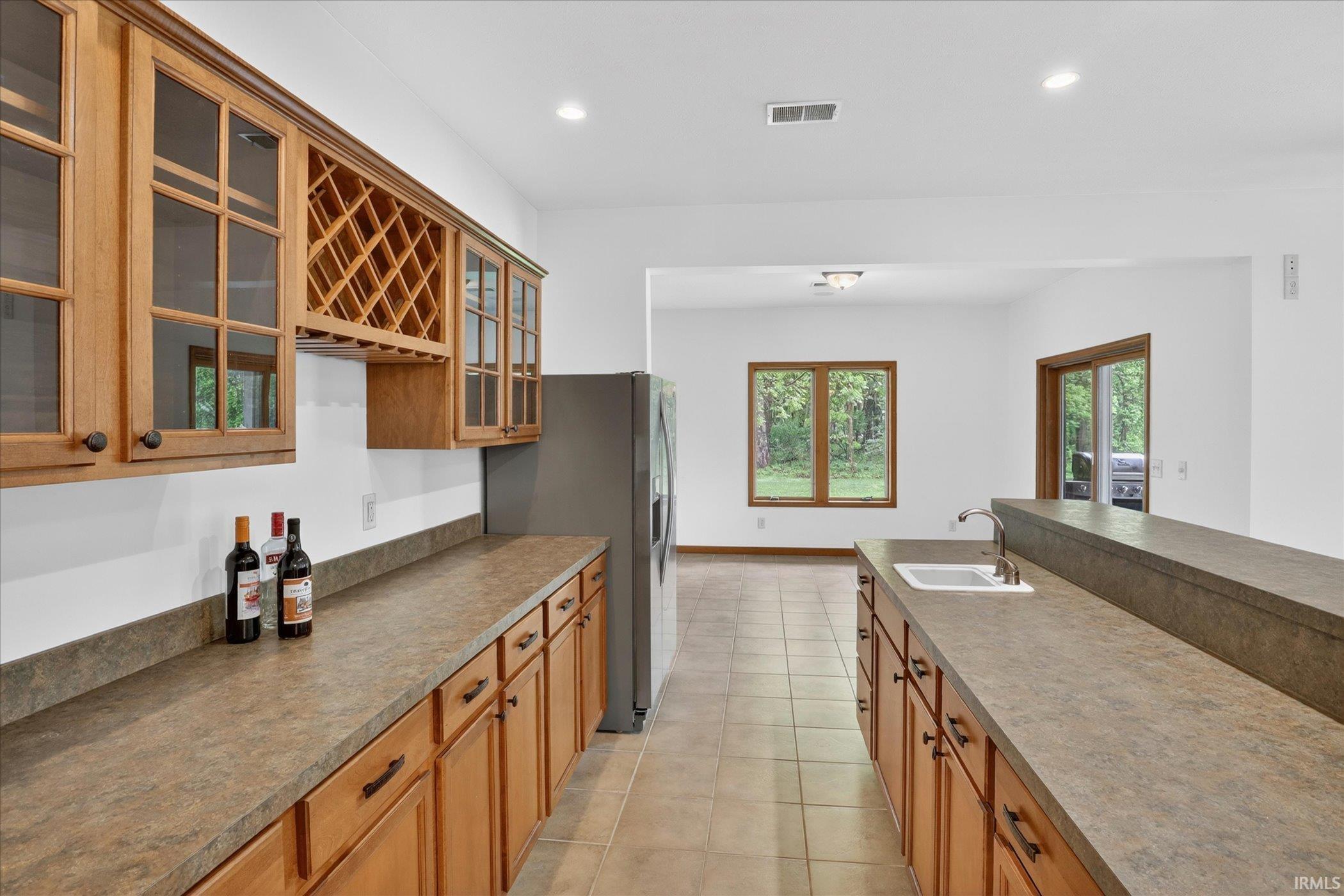 Functional kitchen area featuring light wood cabinetry, integrated wine rack, and extensive countertop space