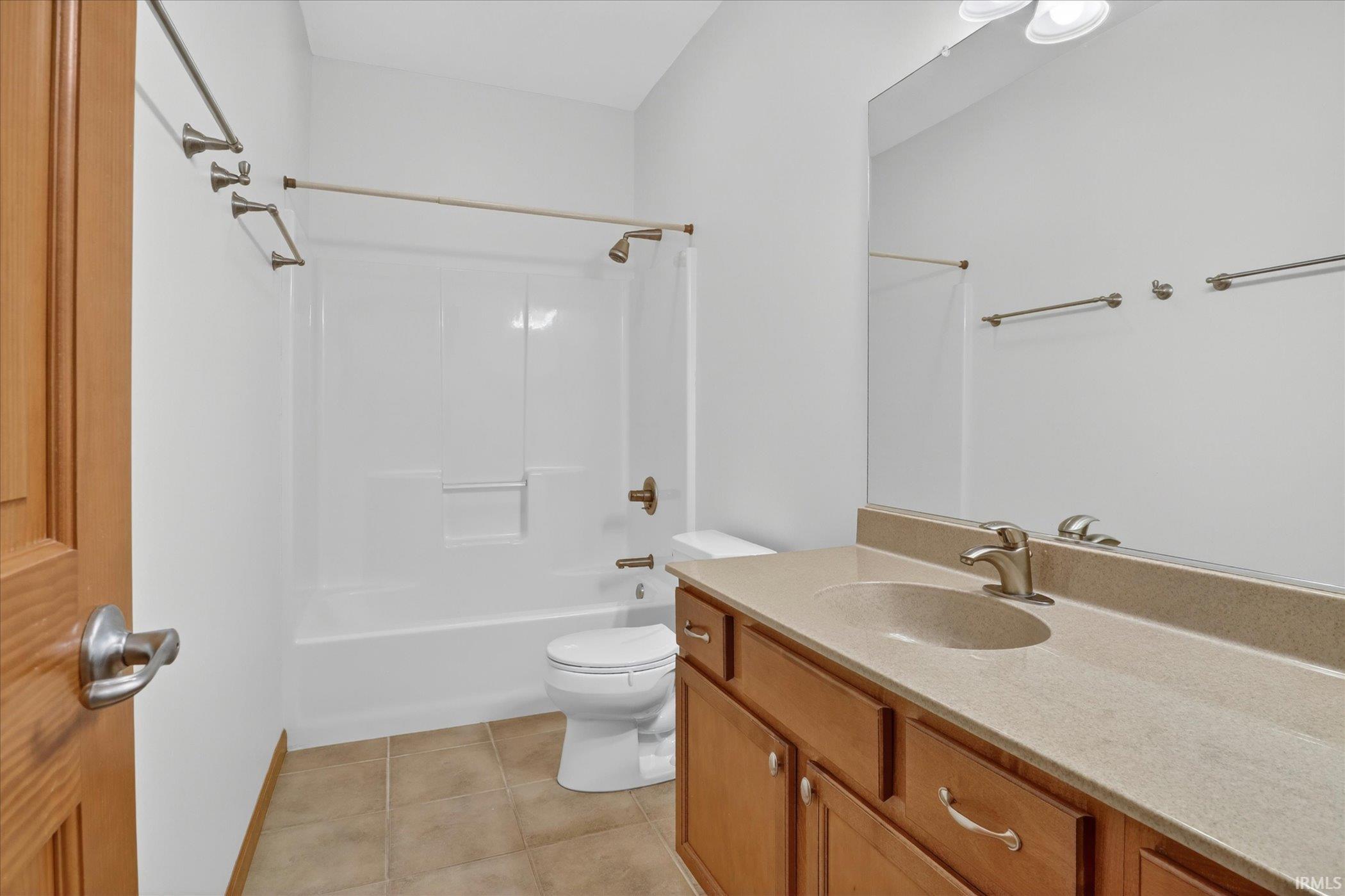 Bathroom featuring a wood-finish vanity with a single basin sink and a light-toned countertop