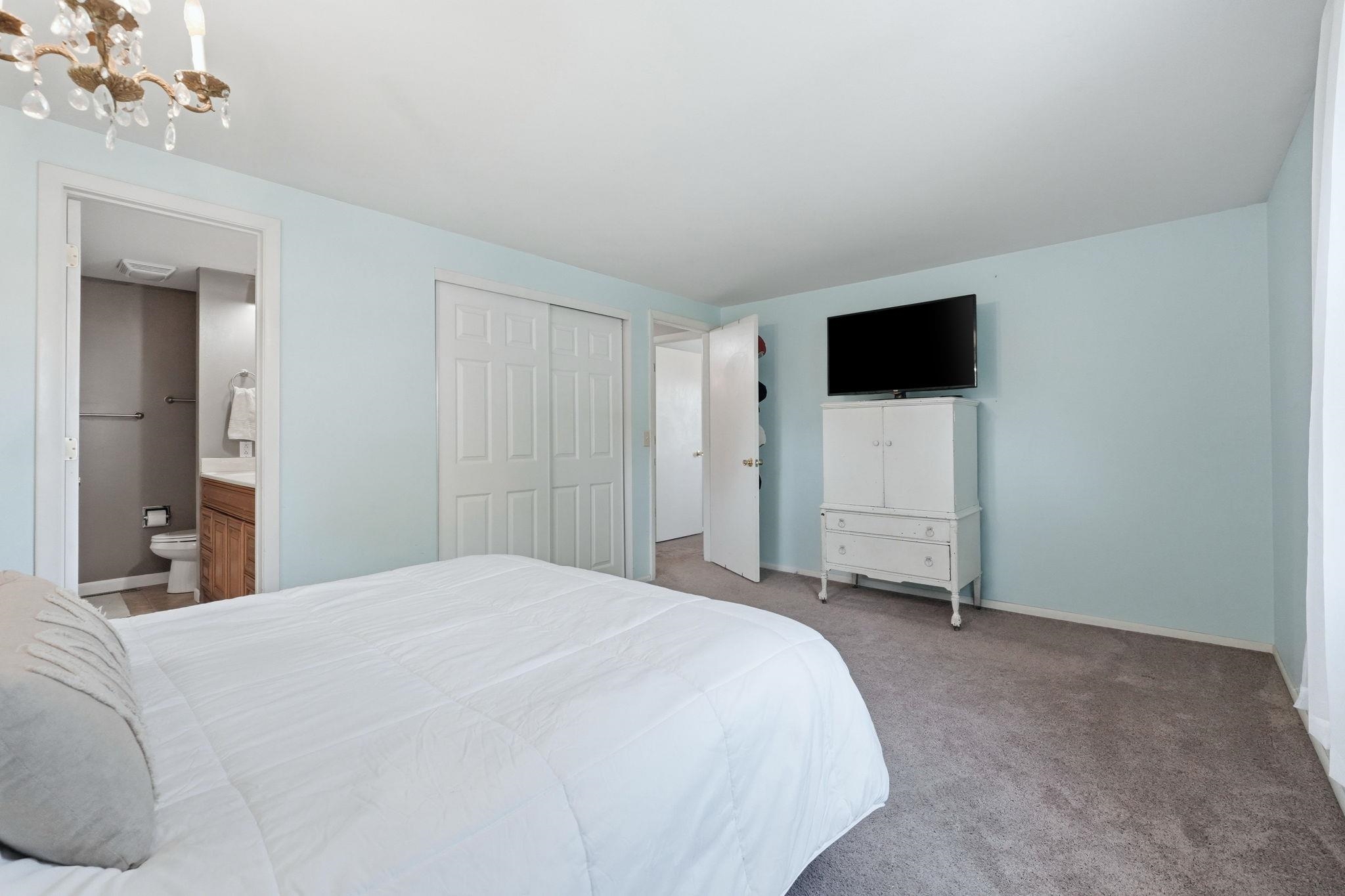 Bedroom with light blue walls and gray carpeting