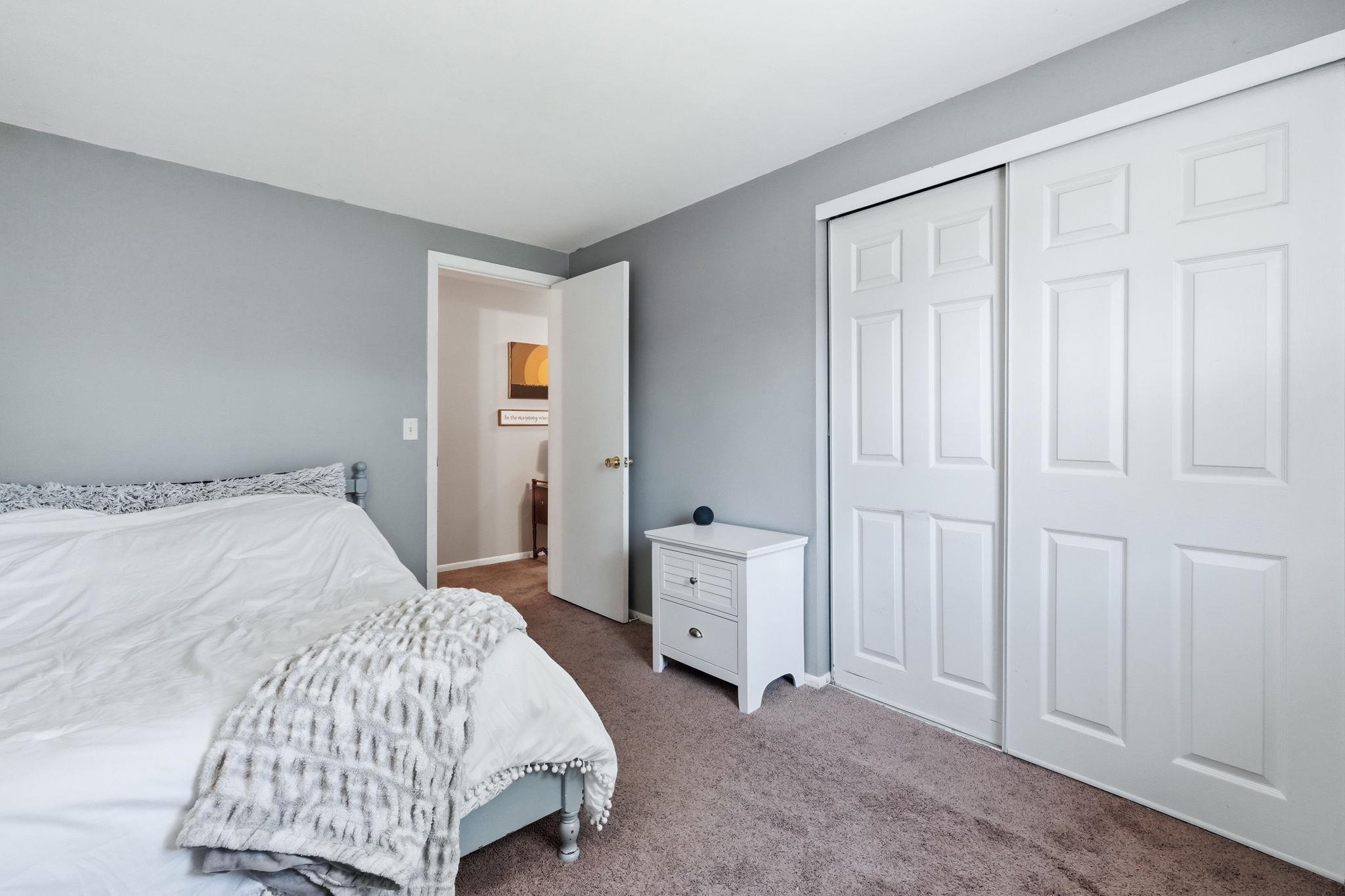 Wall-to-wall carpeting in a neutral tone complements the light gray wall paint
