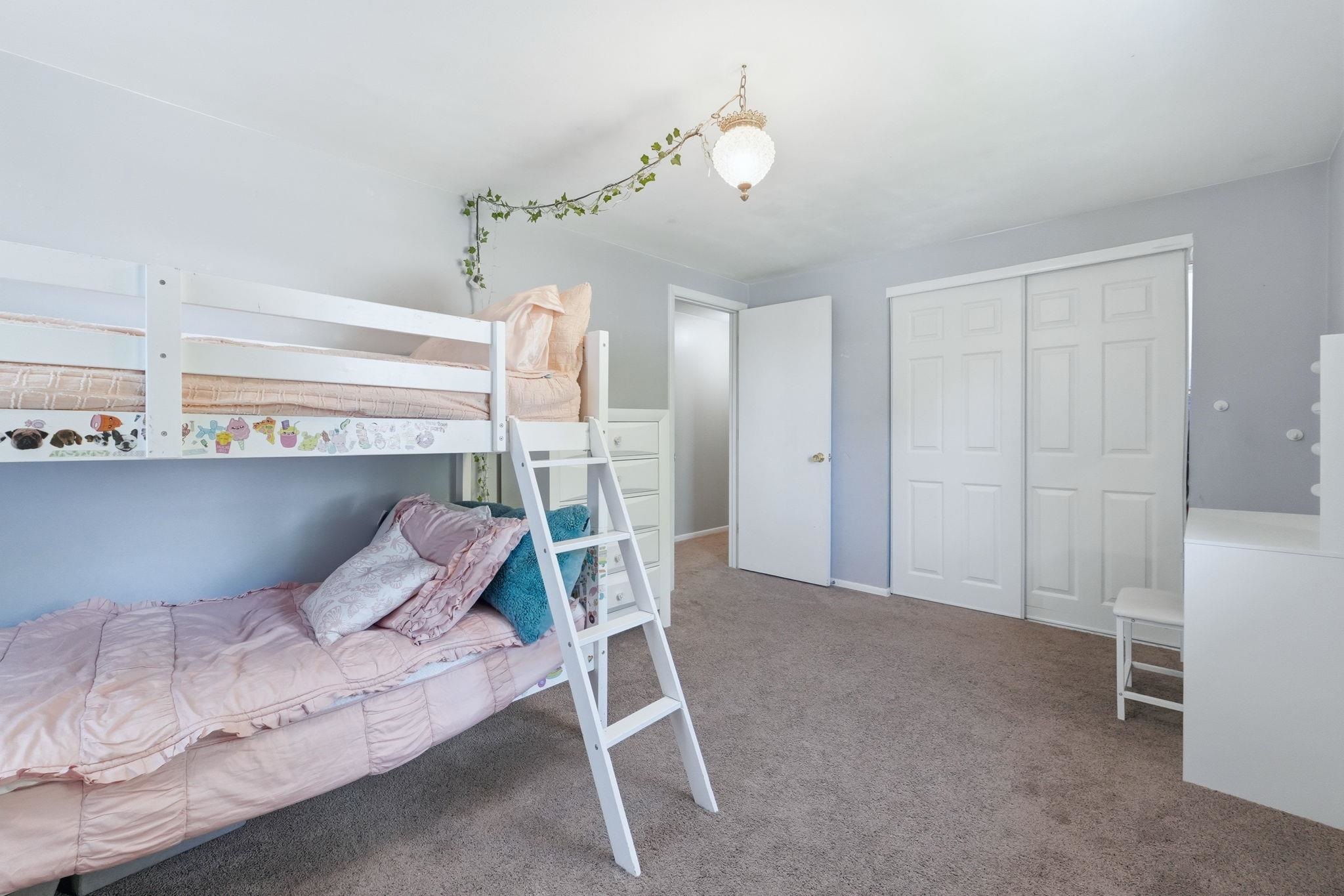 Bedroom featuring soft gray walls, neutral carpet flooring, and a ceiling-mounted light fixture