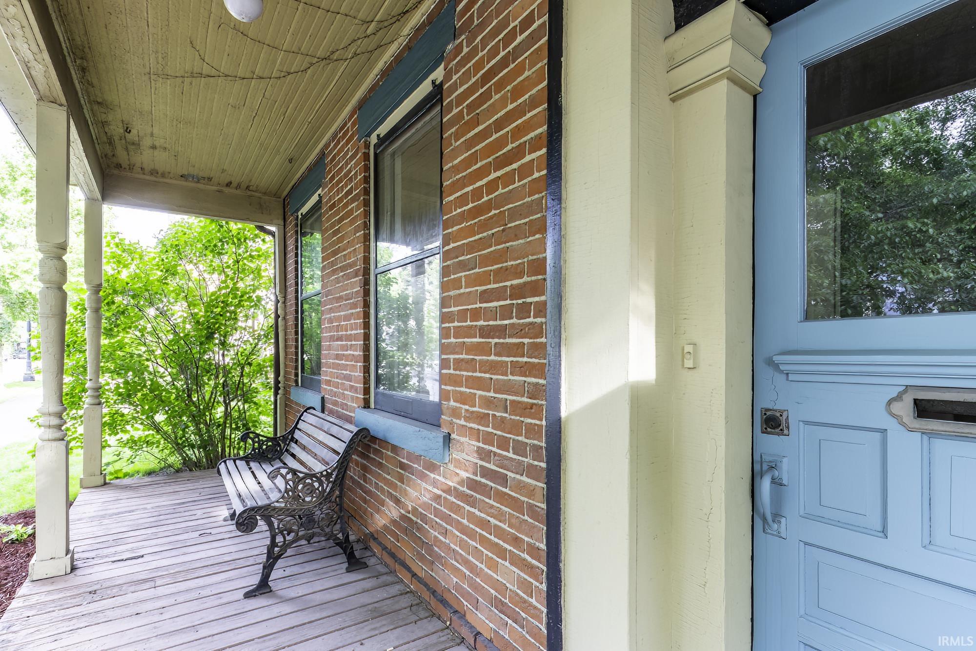 Brick exterior with a light blue front door and a covered porch