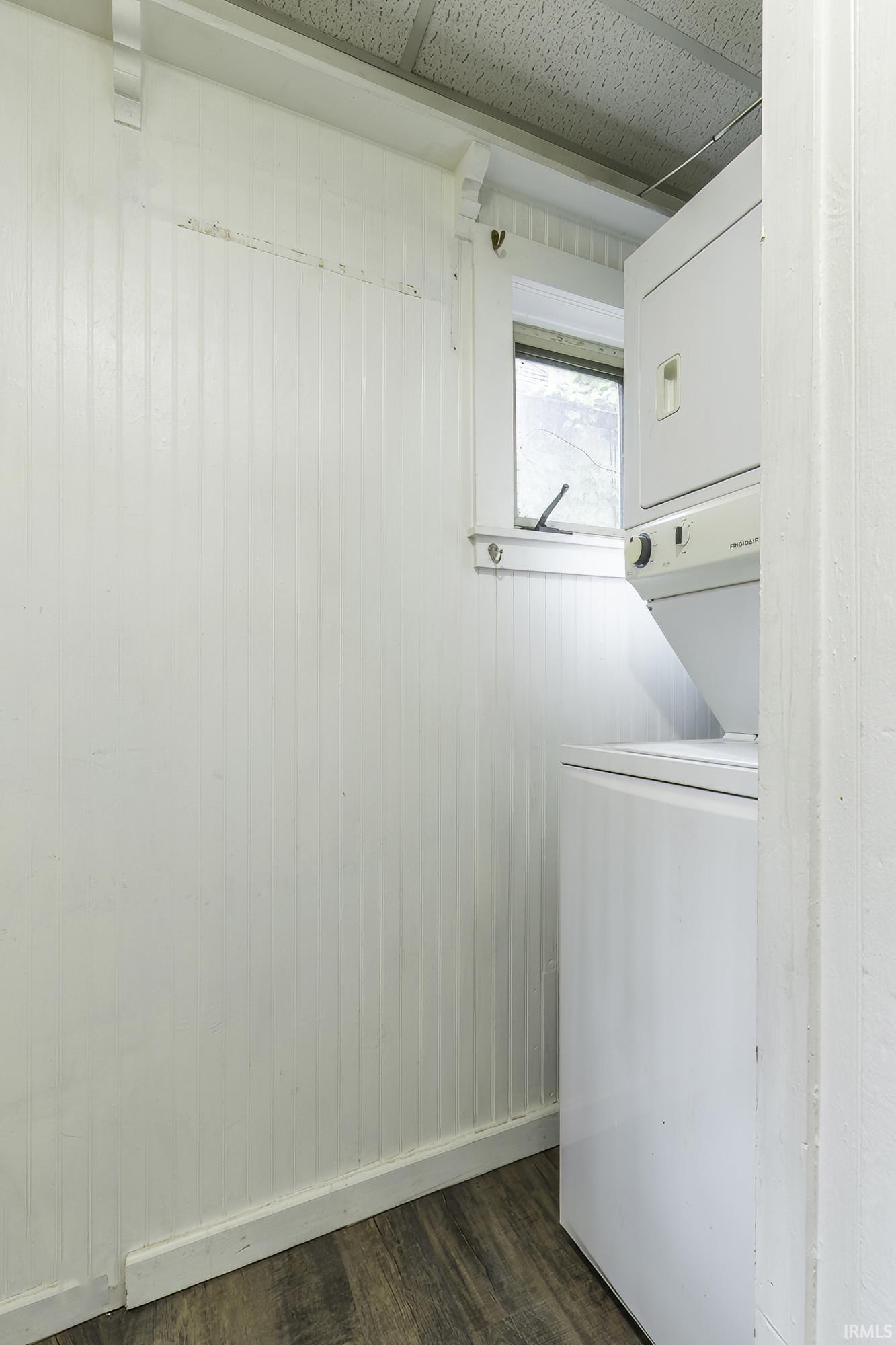 Dedicated laundry area featuring a stacked washer and dryer unit