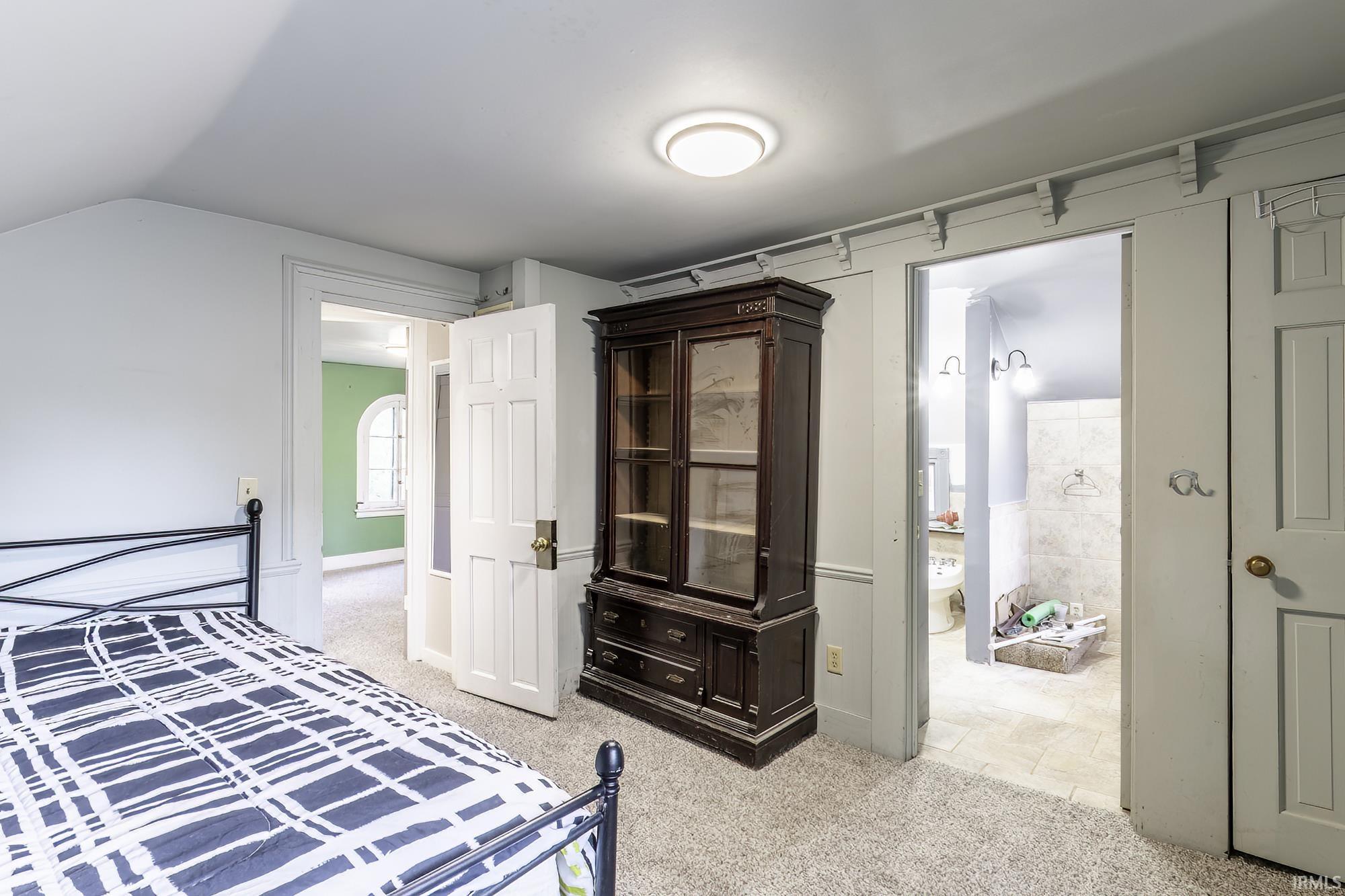 Carpeted room with a ceiling-mounted light fixture and white trim