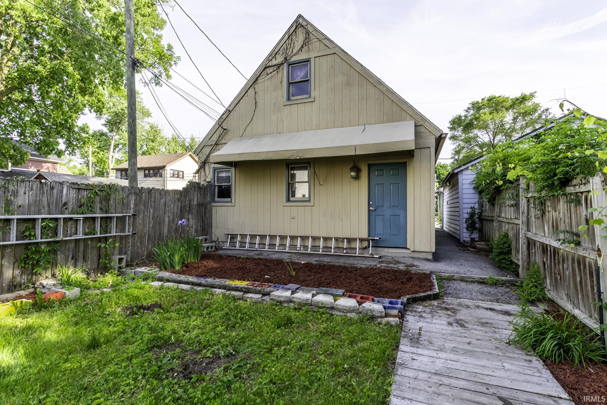Rear exterior with a pitched roofline and light-colored siding