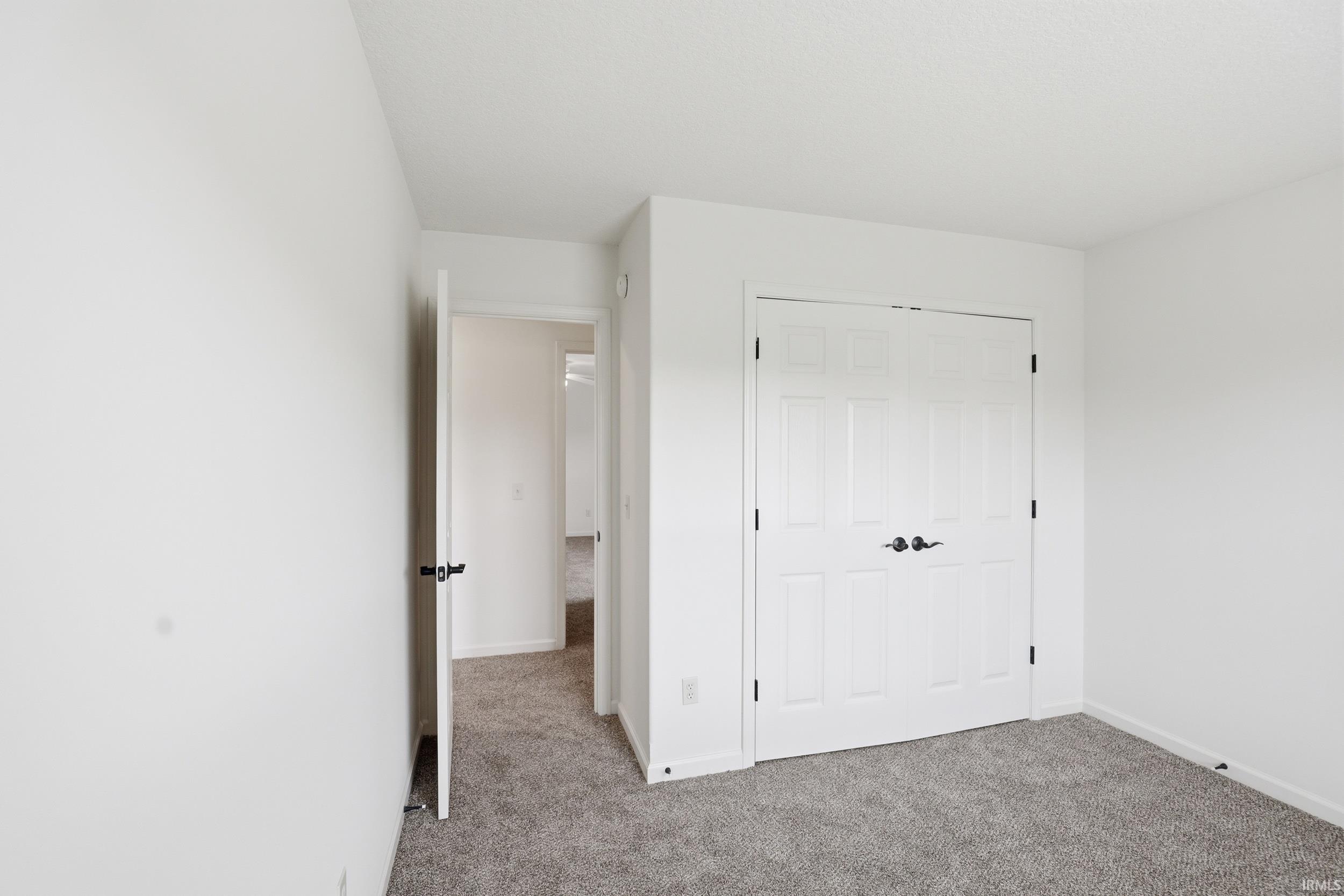 White paneled bi-fold closet doors with dark hardware