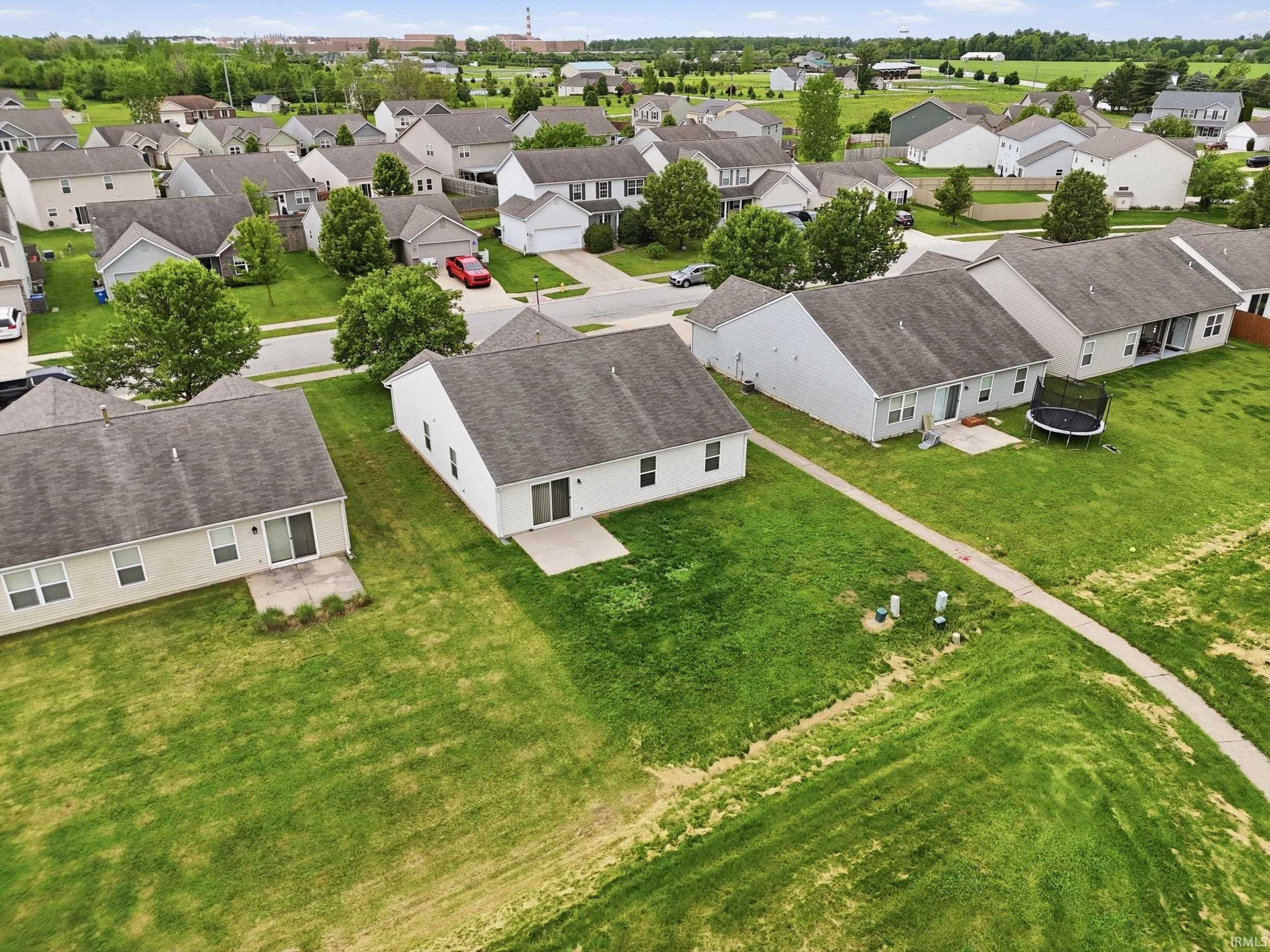 Overhead view showcasing residential properties with light-colored siding and dark shingle roofs