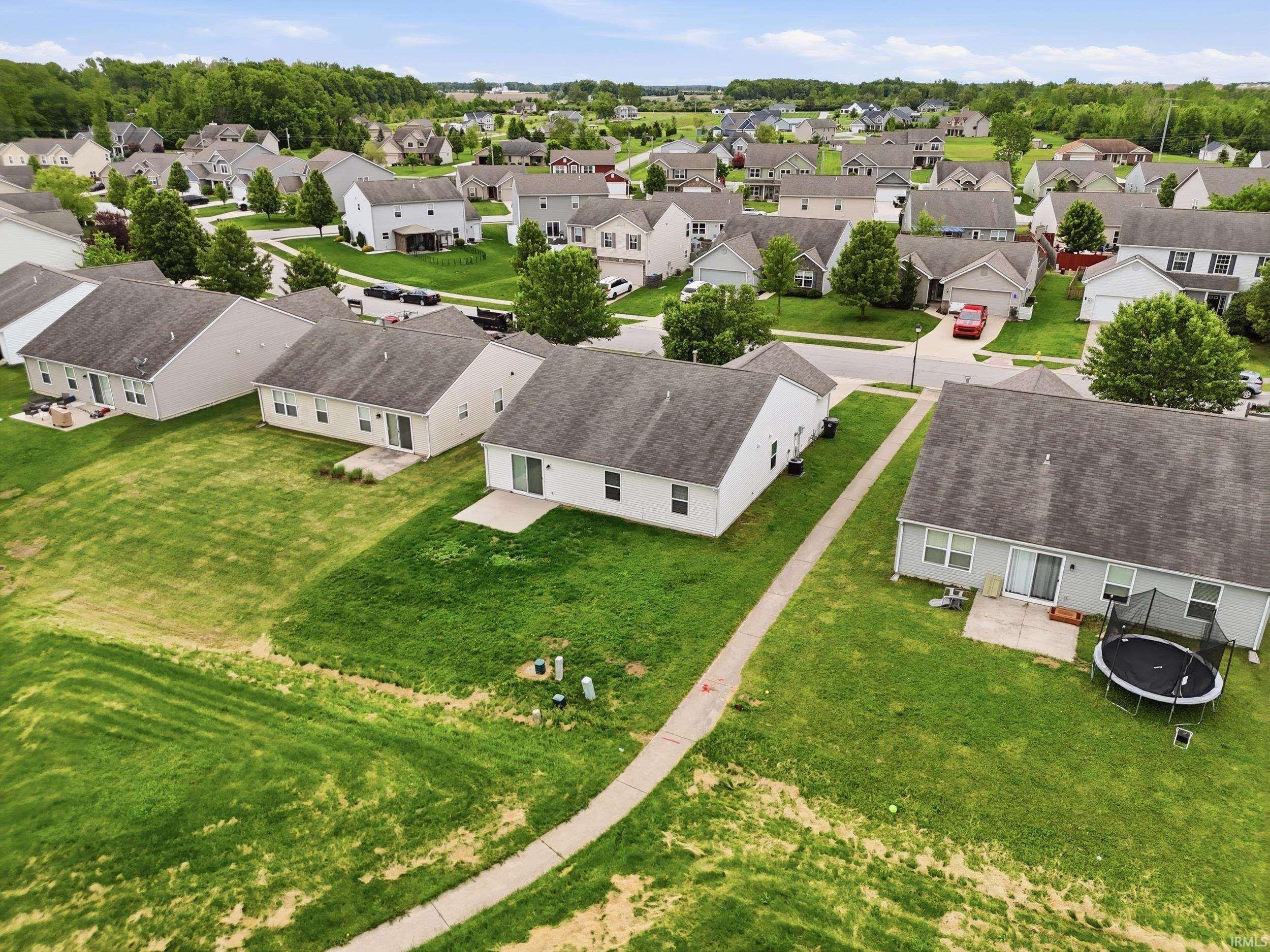 Residential neighborhood featuring detached homes with grey shingle roofs and light-colored siding