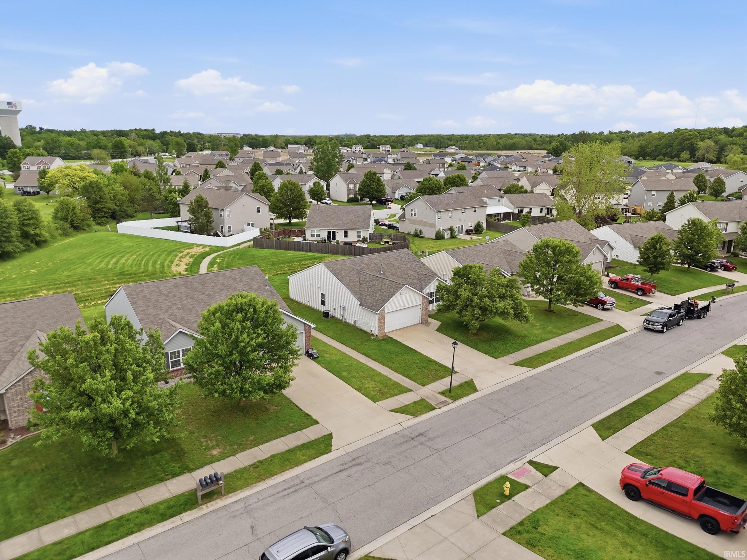 Residential street with single-story homes featuring attached garages, concrete driveways, and manicured lawns