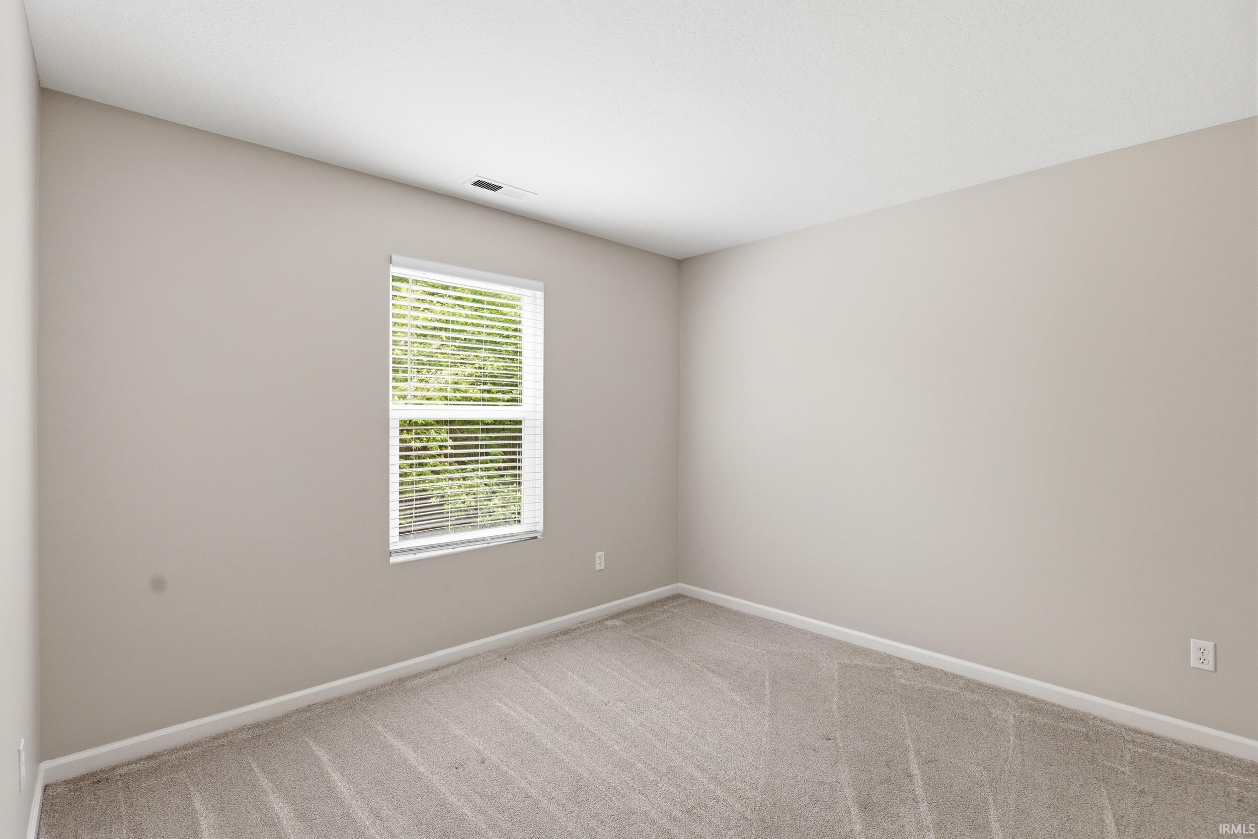 Neutral-toned walls and gray patterned carpeting define this room