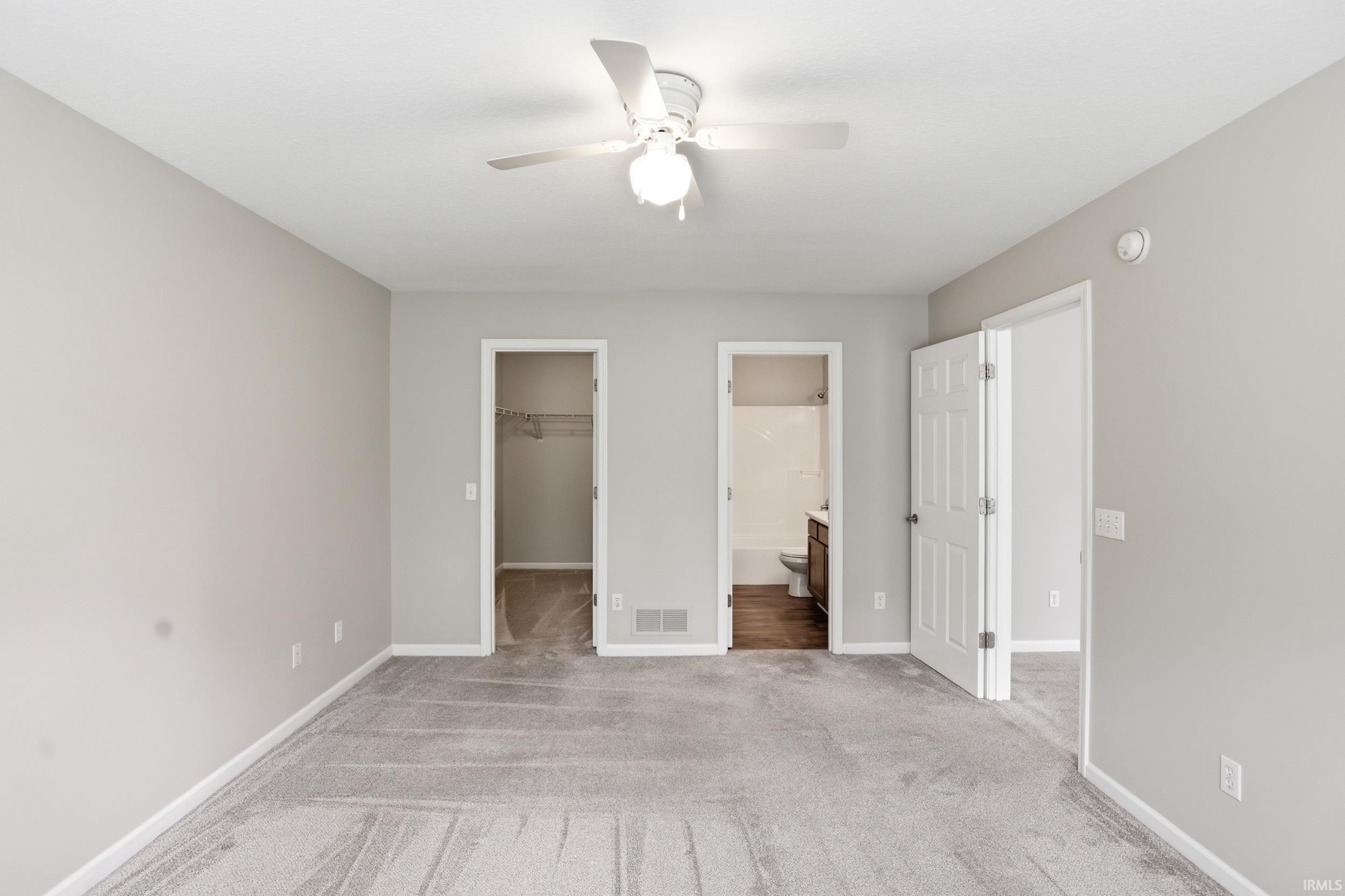 Spacious room featuring neutral carpeting and light gray wall paint