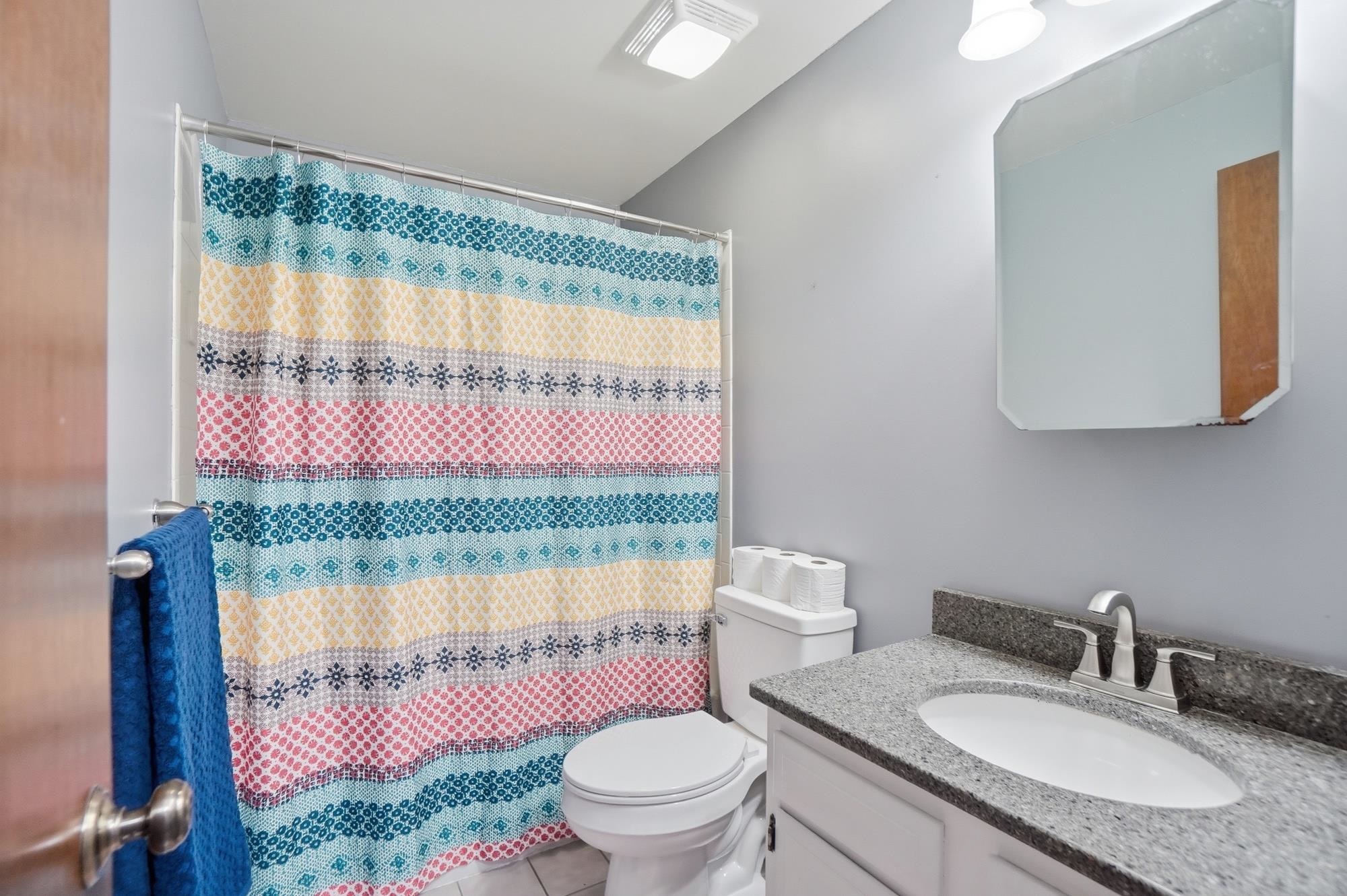 Bathroom vanity with a granite-look countertop, integrated sink, and brushed nickel faucet
