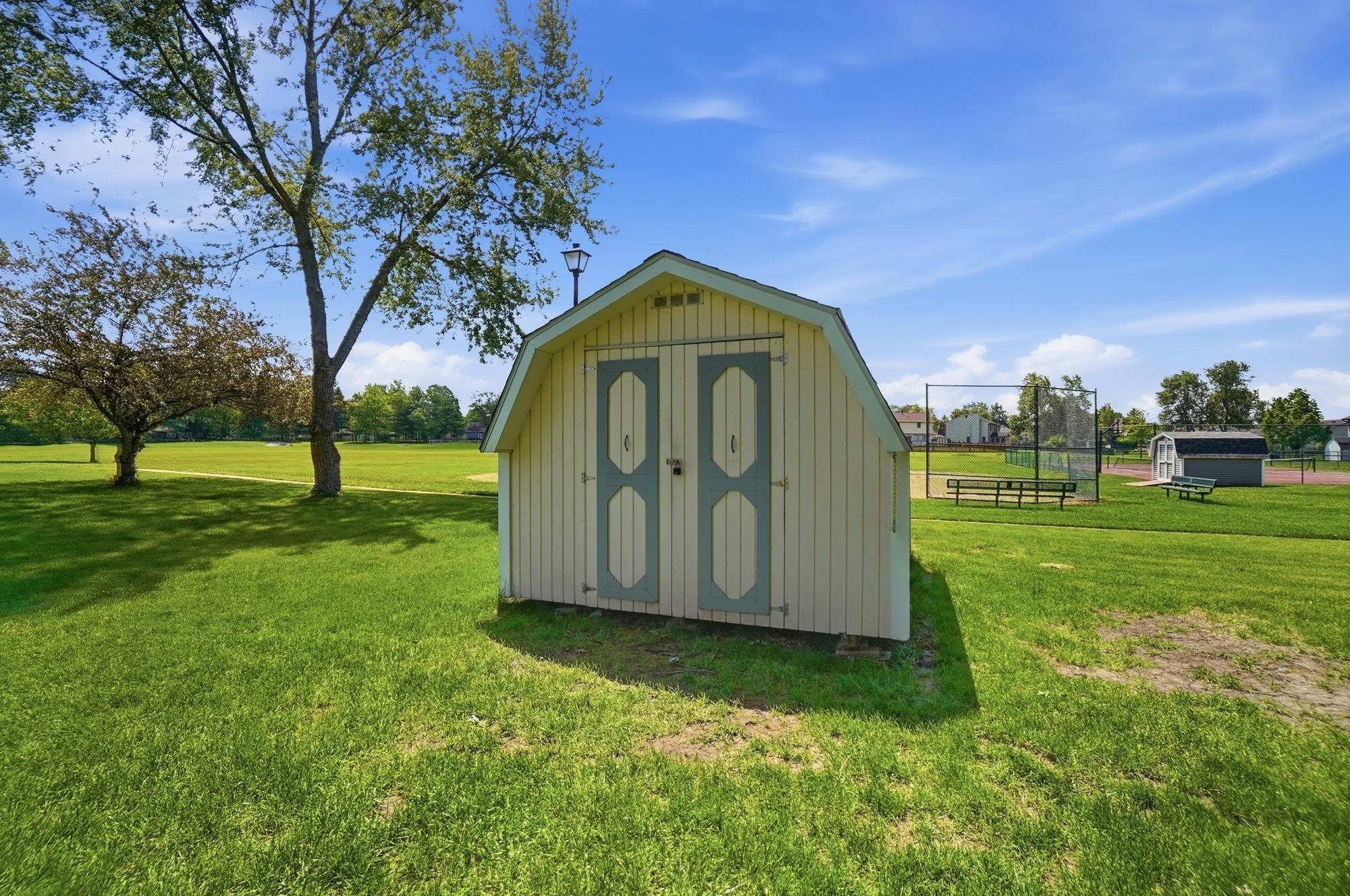 A-frame storage shed with double doors, set on a grassy expanse