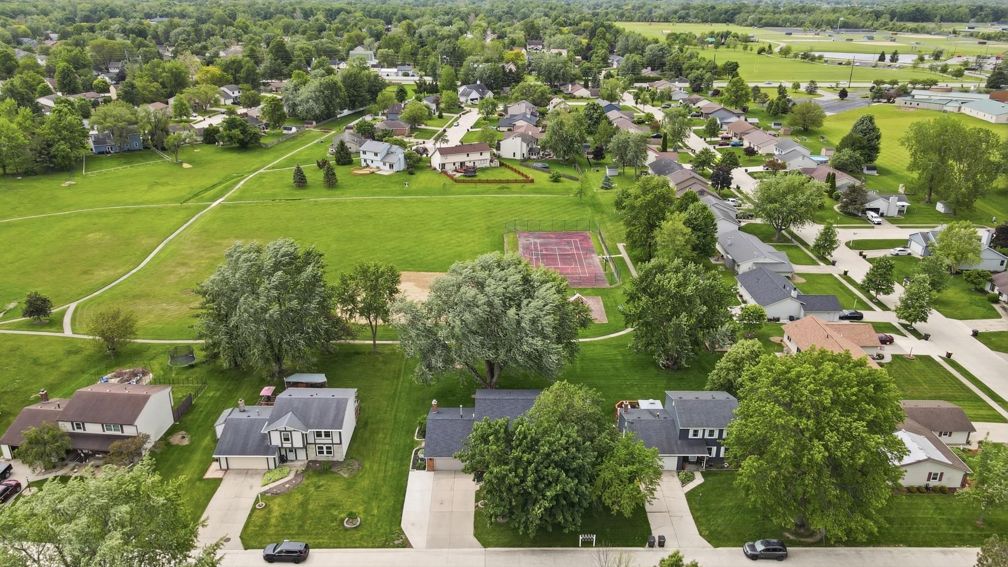 Expansive green spaces and mature trees surround residential properties