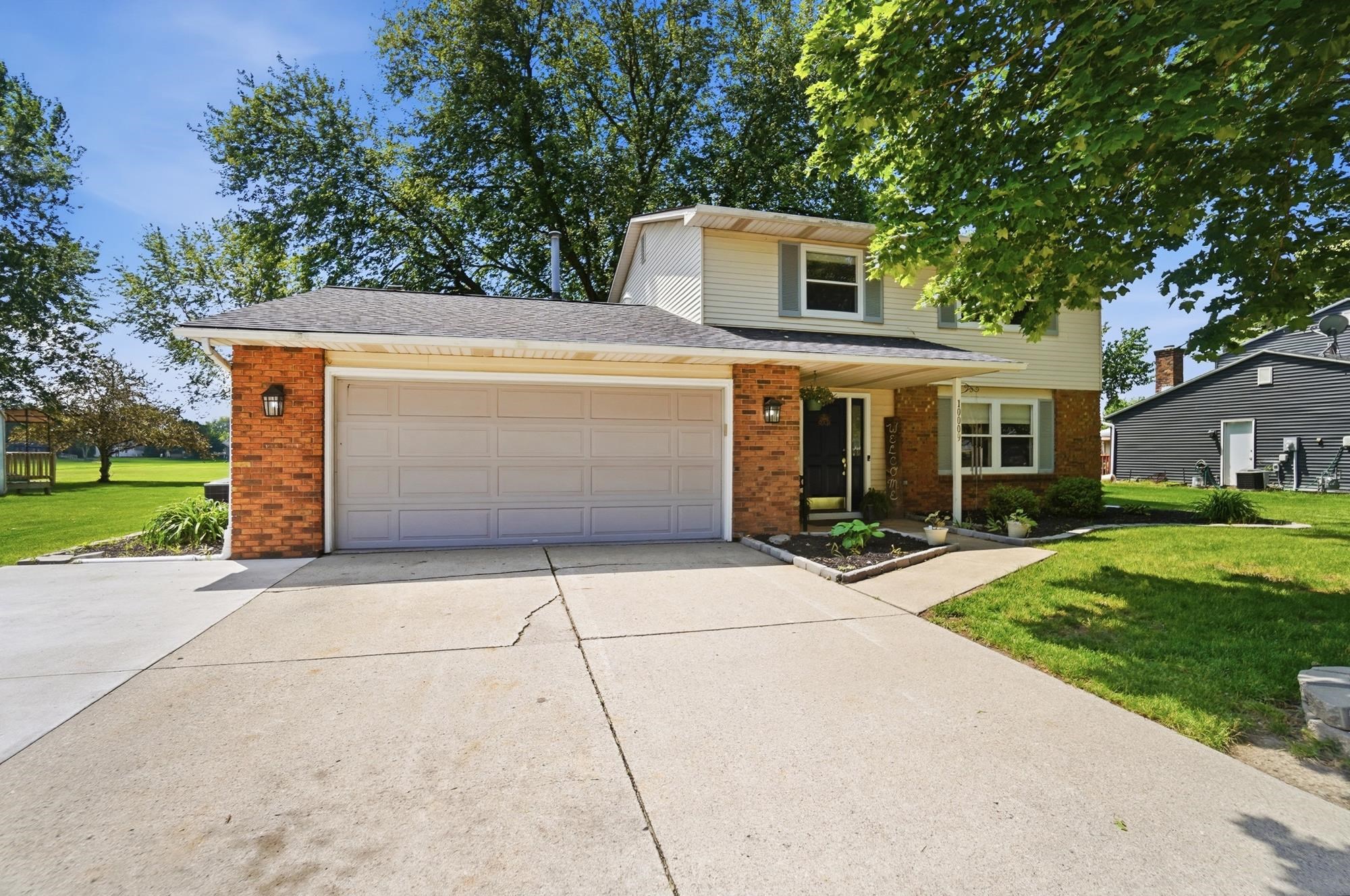 Two-story residence featuring brick and siding exterior, an attached two-car garage, and a concrete driveway