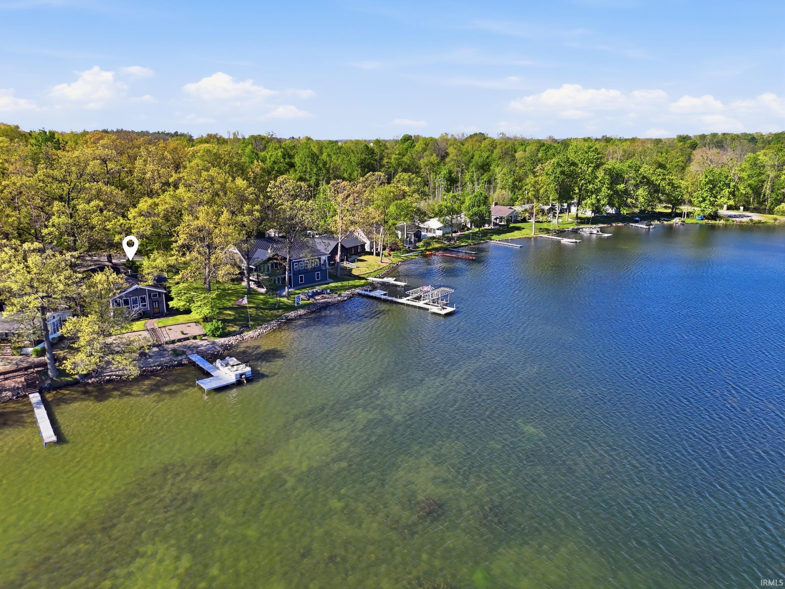 Expansive waterfront property featuring a private dock, forested surroundings, and direct lake access